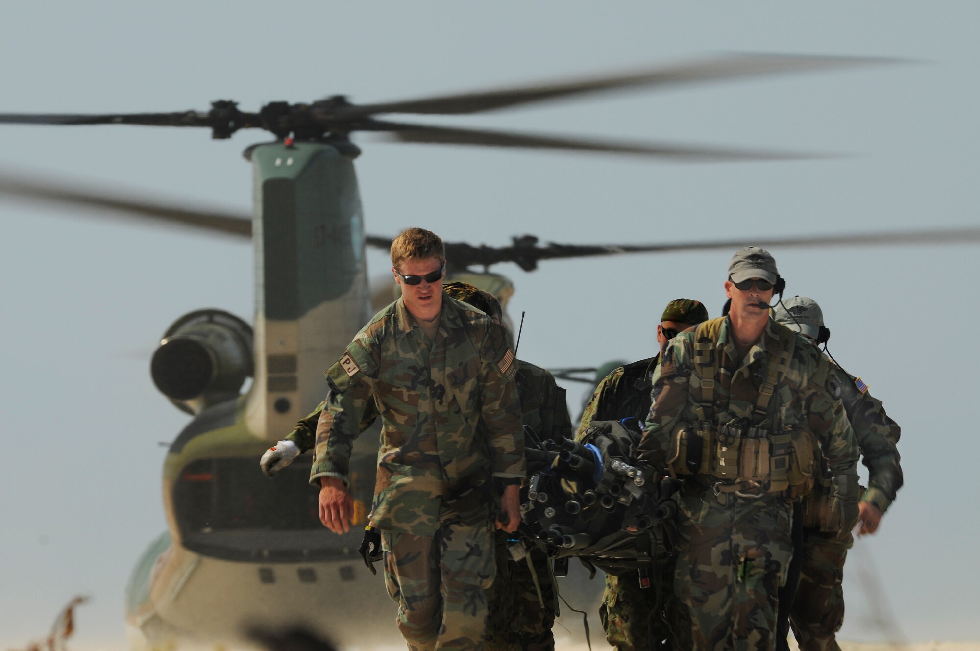 U.S. Air Force Pararescuemen and Japanese Air Self Defense Force (JASDF) Air Rescue personnel carry a litter of supplies from a CH-47 Chinook helicopter on a beach off the coast of Okinawa, Japan during exercise Cope Angel 09-1, Feb. 12, 2009. Cope Angel is a joint rescue exercise between members of the U.S. Air Force and the JASDF. (U.S. Air Force photo/Airman 1st Class Chad Warren)