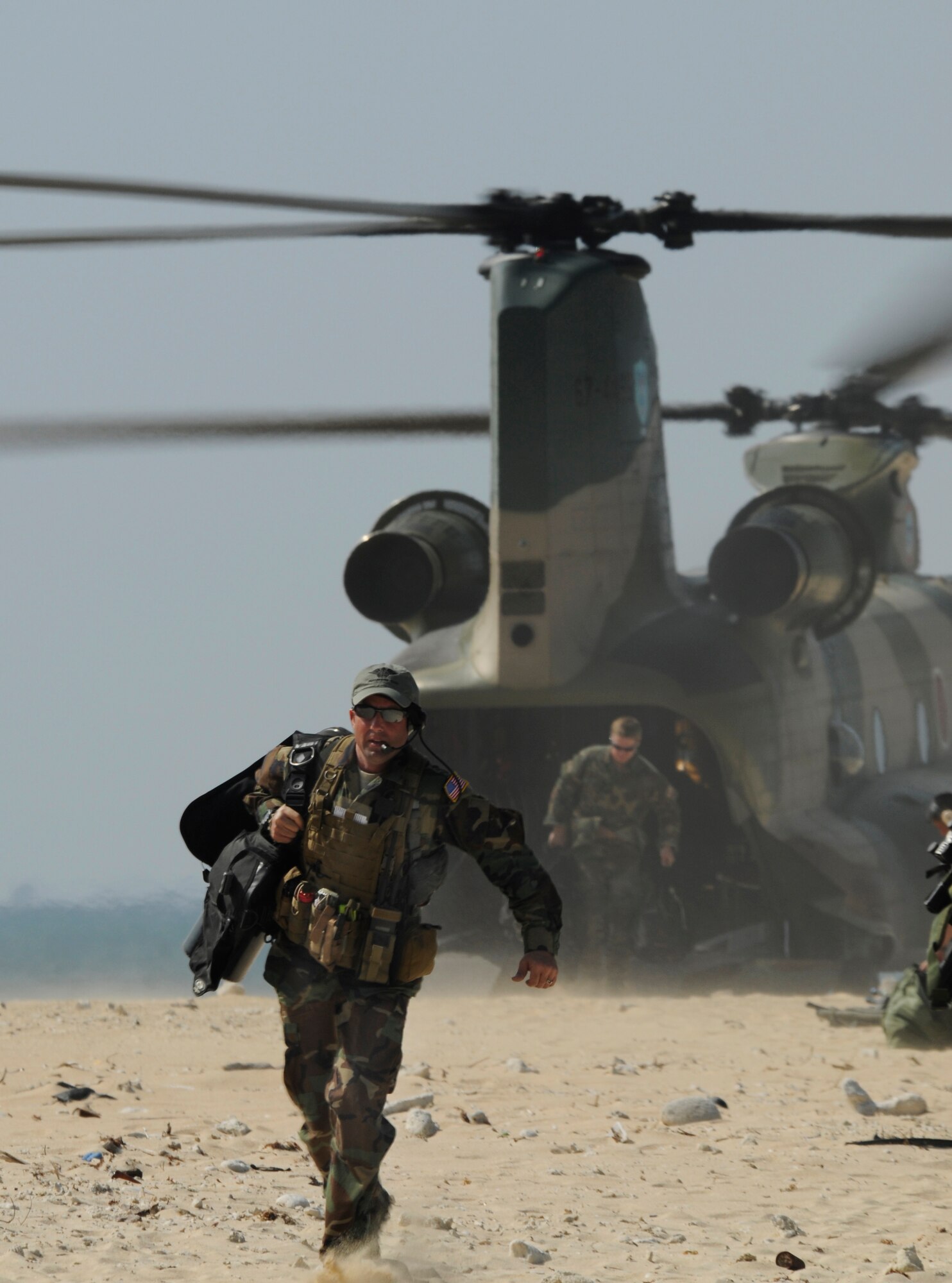 Captain Harmon, a combat rescue officer with the 31st Rescue Squadron, runs to his team after exiting a CH-47 Chinook helicopter on a beach off the coast of Okinawa, Japan during exercise Cope Angel 09-1, Feb. 12, 2009. Cope Angel is a joint rescue exercise between members of the U.S. Air Force and the Japanese Air Self Defense Force. (U.S. Air Force photo/Airman 1st Class Chad Warren)