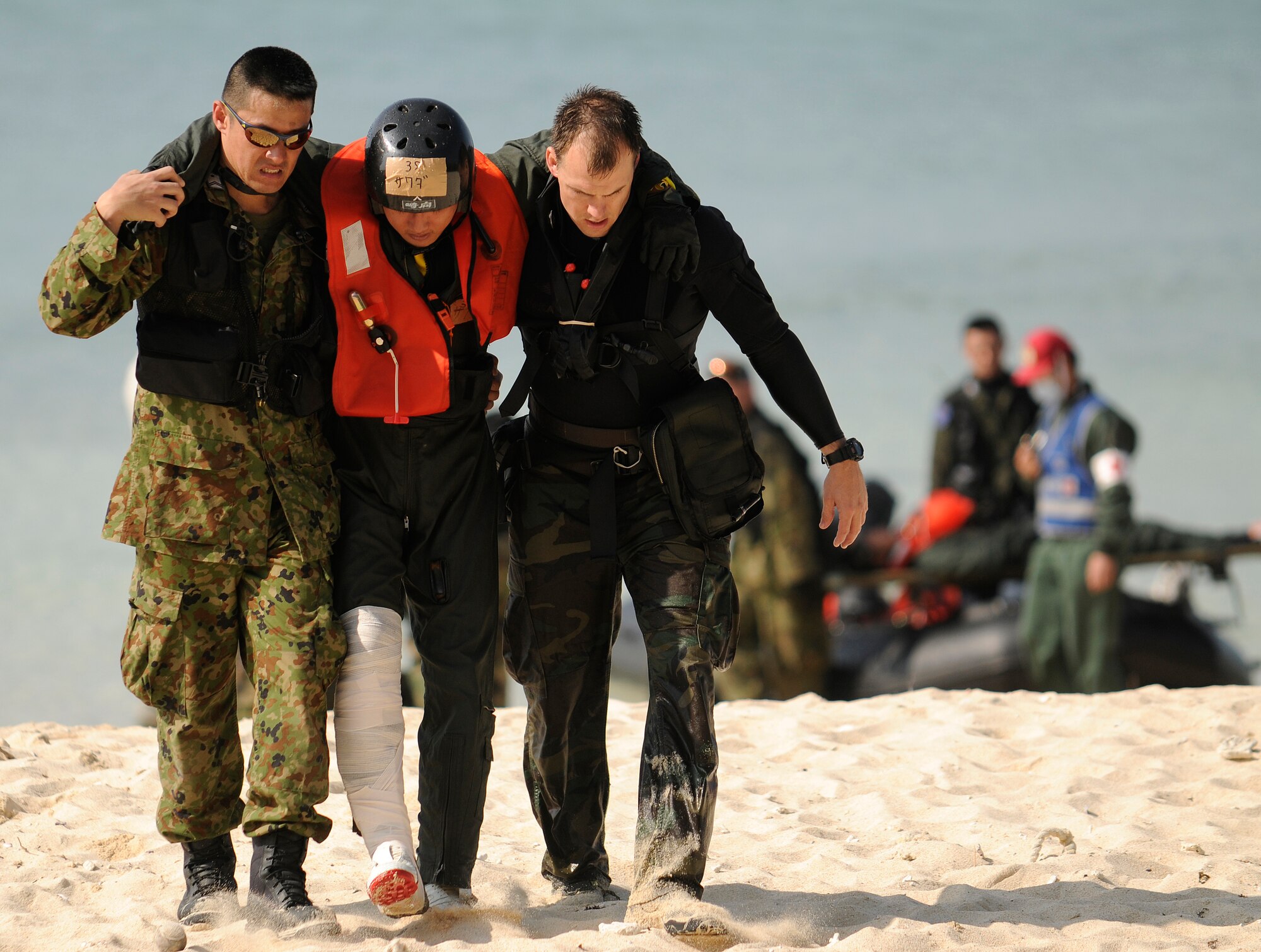 U.S. Air Force Pararescuemen and Japanese Air Self Defense Force (JASDF) Air Rescue personnel help a simulated survivor to a collection point on a beach off the coast of Okinawa, Japan during exercise Cope Angel 09-1, Feb. 12, 2009. Cope Angel is a joint rescue exercise between members of the U.S. Air Force and the JASDF. (U.S. Air Force photo/Airman 1st Class Chad Warren)