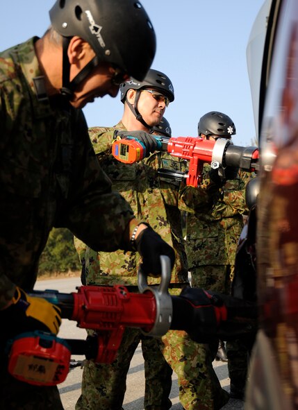 Air rescue personnel from the Japanese Air Self Defense Force (JASDF) use the jaws of life to remove a car door during exercise Cope Angel 09-1, Feb. 11, 2009. Cope Angel is a joint rescue exercise between members of the U.S. Air Force and the JASDF. (U.S. Air Force photo/Airman 1st Class Chad Warren)