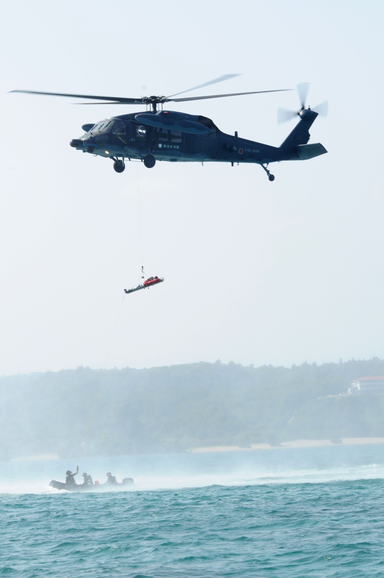 A JASAF UH-60 Black Hawk hoists up a victim during exercise Cope Angel 09-1, Feb. 12, 2009. Cope Angel is a joint rescue exercise between members of the U.S. Air Force and the Japanese Air Self Defense Force.  (U.S. Air Force photo/Staff Sgt Chrissy Best)