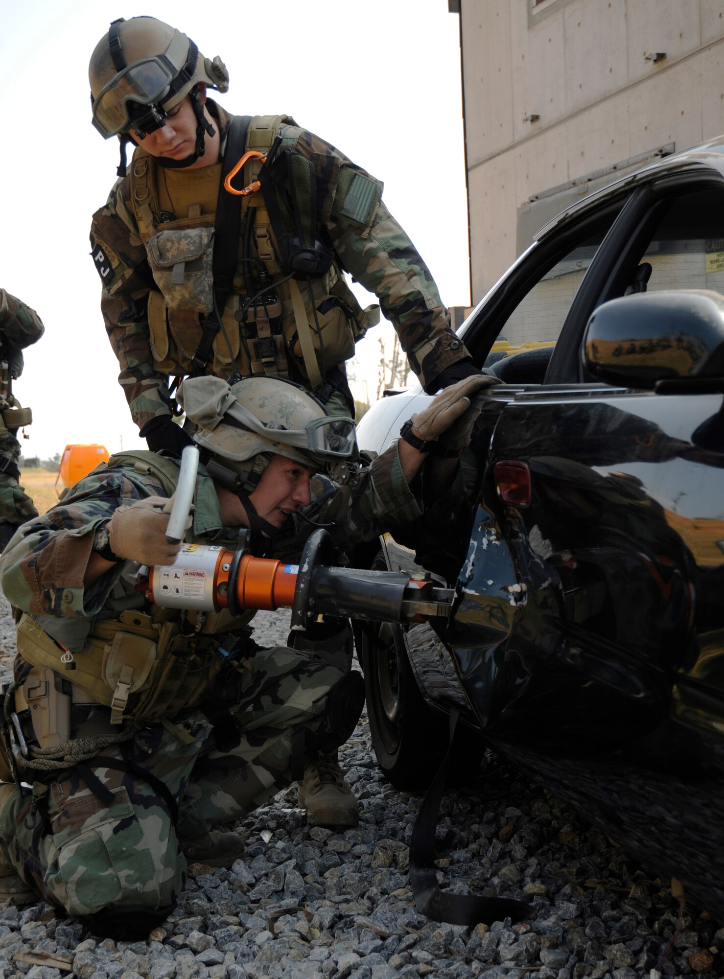 Staff Sgt. Kenneth Ortega (bottom) and Senior Airman Jonathan Seydel, both pararescuemen assigned to the 31st Rescue Squadron, Kadena Air Base, Japan, use the jaws of life to force open a car door during exercise Cope Angel 09-1, Feb. 10, 2009. Cope Angel is a joint rescue exercise between members of the U.S. Air Force and the Japanese Air Self Defense Force. (U.S. Air Force photo/Airman 1st Class Chad Warren)