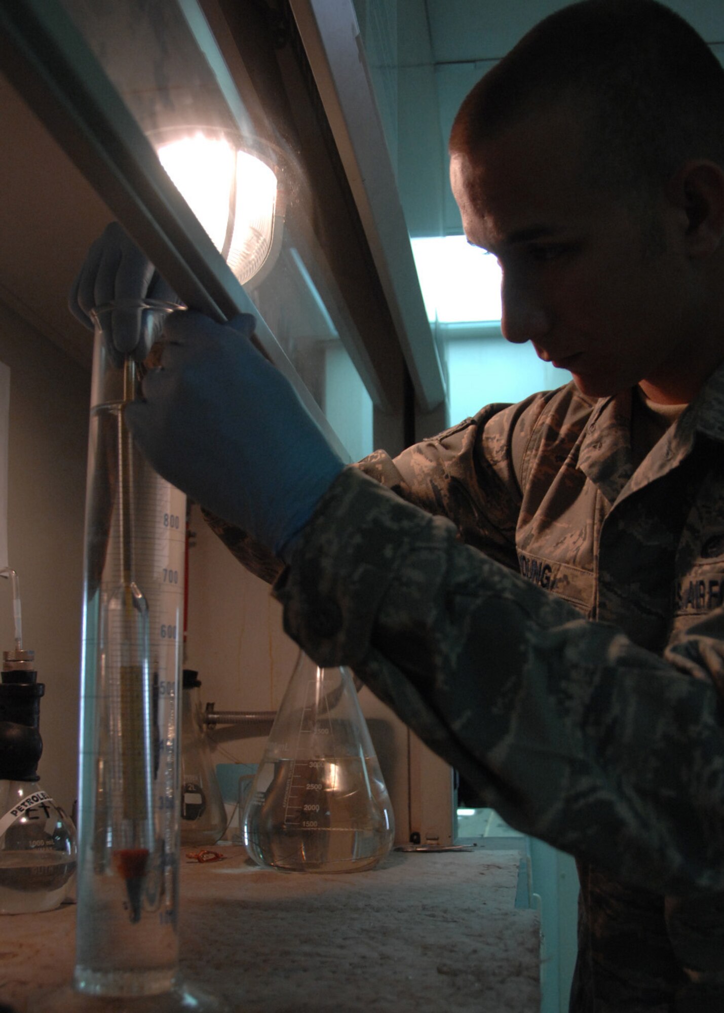 SOUTHWEST ASIA -- Senior Airman Matthew Young, 386th Expeditionary Logistics Readiness Squadron, lowers a hydrometer into jet fuel to perform an API gravity test at an air base in Southwest Asia, Feb. 12. API Gravity is the measurement of fuel's density and can provide valuable information about a fuel's composition and combustion characteristics. Airman Young is deployed from RAF Lakenheath, England, and is originally from Dallas. (U.S. Air Force photo/Senior Airman Courtney Richardson)