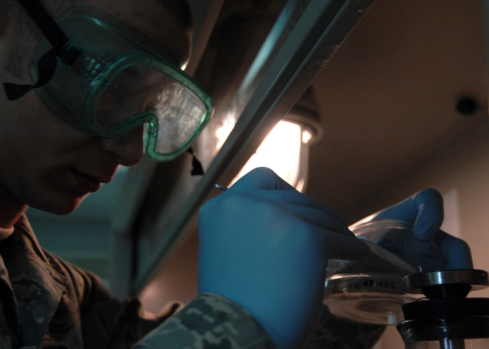 SOUTHWEST ASIA -- Senior Airman Matthew Young, 386th Expeditionary Logistics Readiness Squadron, removes the filter membrane from a flask containing jet fuel after performing the Bottle Method test at an air base in Southwest Asia, Feb. 12. The Bottle Method test determines the amount of particulate contaminaton in the fuel. Airman Young is deployed from RAF Lakenheath, England, and is from Dallas. (U.S. Air Force photo/Senior Airman Courtney Richardson)