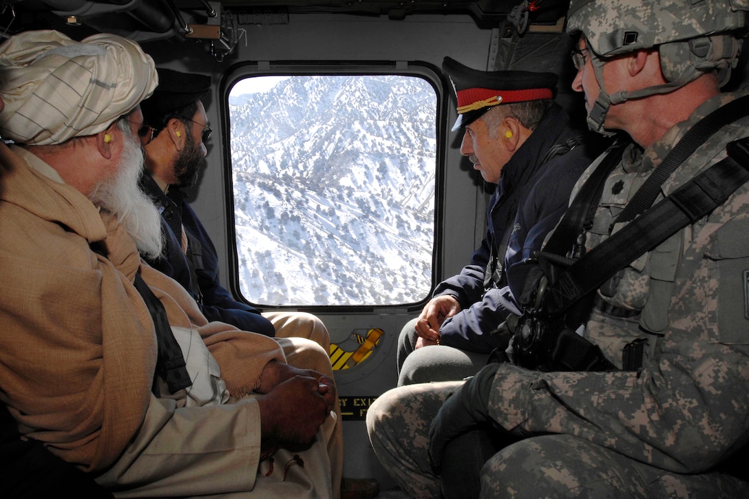 U.S. Air Force Lt. Col. Dan Moy, far right, commander for Afghanistan's Paktia Provincial Reconstruction Team, travels by Black Hawk helicopter to a remote combat outpost with the provincial governor, police chief and a religious leader for a meeting with district leaders, Feb. 8, 2009. The team works to get government leaders out to rural districts.