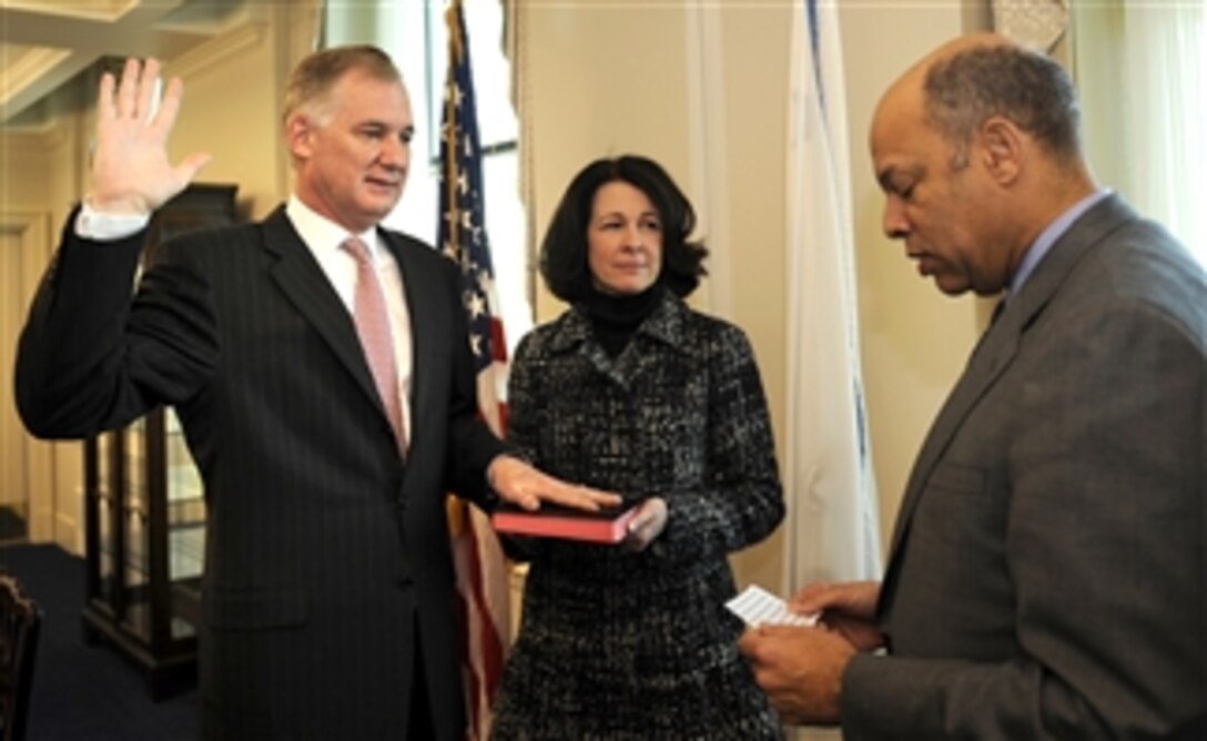 DoD General Counsel Jeh Charles Johnson administers the oath of office to William J. Lynn III as the 30th deputy secretary of defense as Lynn's wife, Mary Murphy, holds the Bible during a Pentagon ceremony on Feb. 12, 2009.  