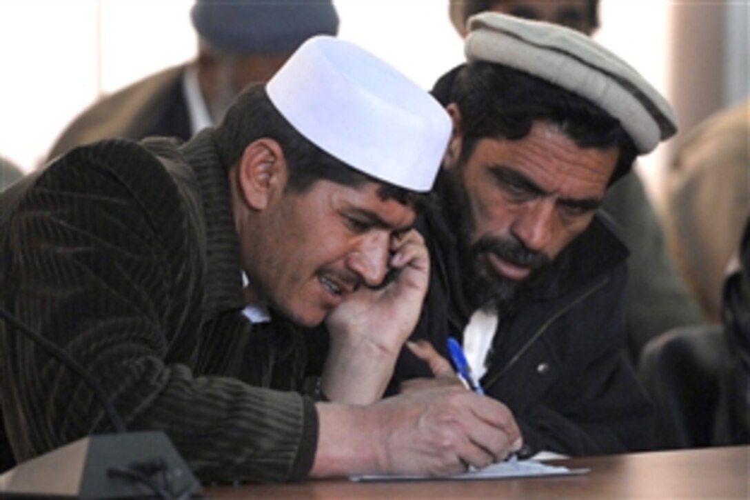 Two local contractors list their contact information on a sign-in sheet at a contractor’s conference, Feb. 7, 2009, at Gardez City, near Forward Operating Base Gardez. The Paktia provincial reconstruction team has about 150 contractors on its list for distributing request for proposals. During the Taliban rule such companies didn’t exist. 