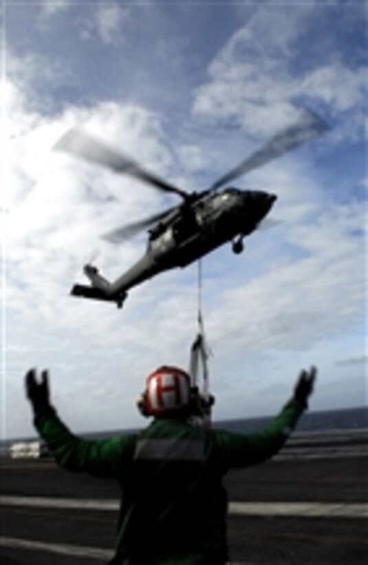 U.S. Navy Petty Officer 3rd Class Marcus J. McElroy directs an MH-60S Sea Hawk from Helicopter Sea Combat Squadron 8 over the flight deck of the aircraft carrier USS John C. Stennis (CVN 74) during a vertical replenishment operation with the USNS Kiska (T-AE 35) in the Pacific Ocean on Feb. 7, 2009.  The Stennis and Carrier Air Wing 9 are on a six-month deployment to the Western Pacific.  