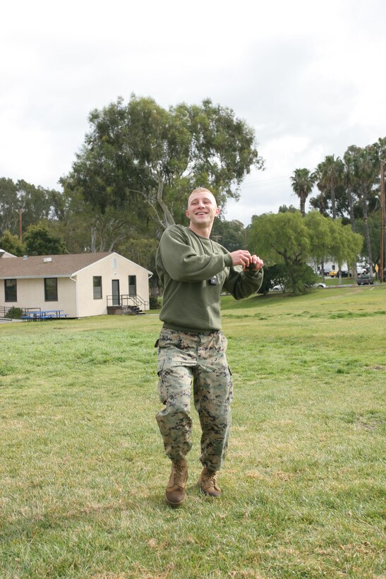 Cpl. Brian D. Bonham, ground training specialist, Headquarters Squadron Marine Corps Air Station. Throws an inert grenade at a 5 yard by 5 yard pit during the movement-under-fire portion of the Combat Fitness Test.