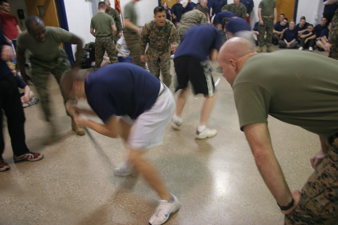 Poolees from four of Recruiting Station Milwaukee's substations battle to keep their balance during the dizzy izzy event of a field meet held at the reserve center here Feb. 14. The annual field meet pits the four metro Milwaukee area substations against each other and fosters friendly competition which will serve the poolees well in their Marine Corps careers.
