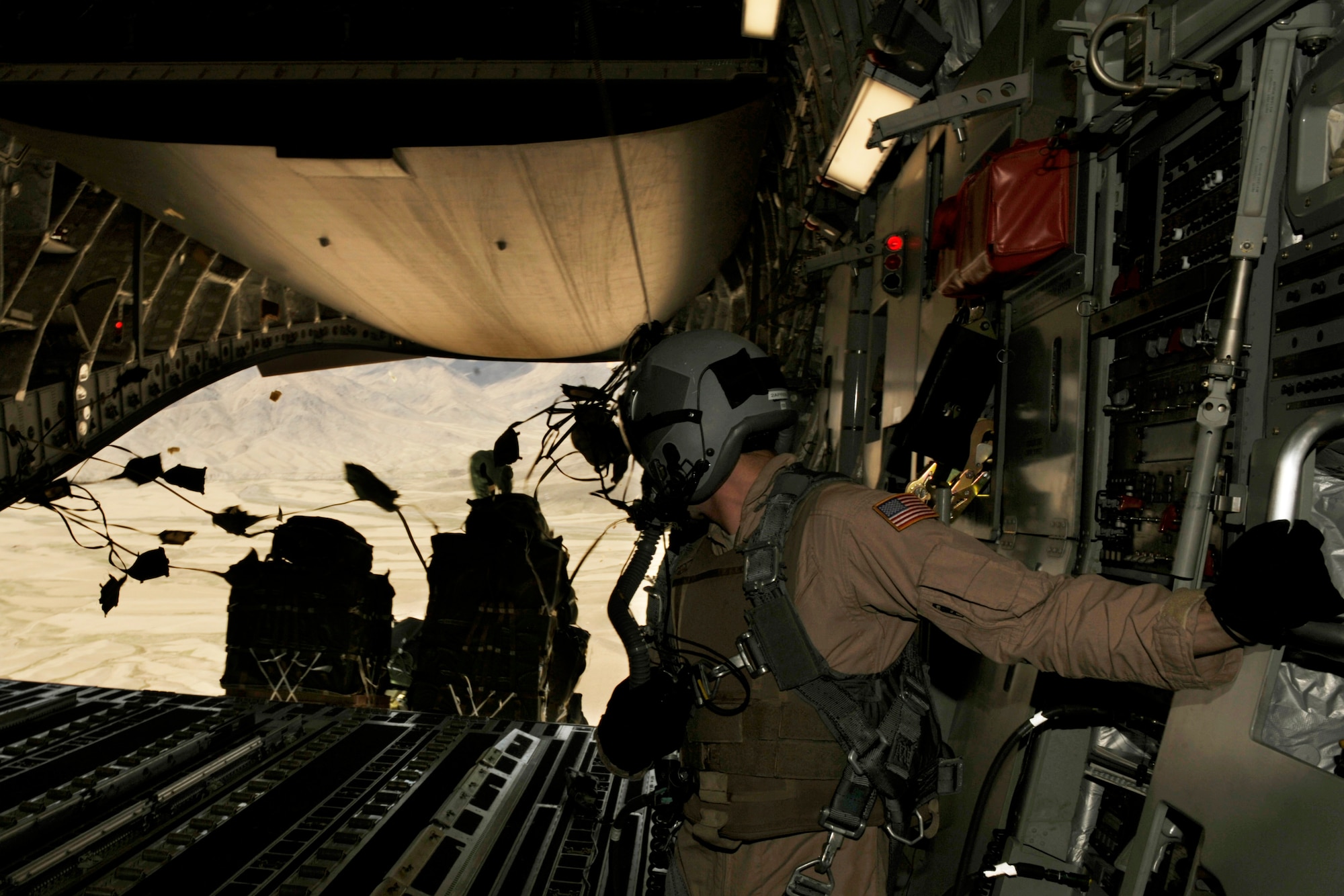 U.S. Air Force Senior Airman Rory Nowosielski, a C-17 Globemaster III loadmaster with the 816th Expeditionary Airlift Squadron, stands on the ramp as Container Delivery System (CDS) bundles exit the aircraft during a high altitude airdrop mission in Afghanistan Feb. 14, 2009, in support of Operation Enduring Freedom. (U.S. Air Force photo by Staff Sgt. James L. Harper Jr.)Released