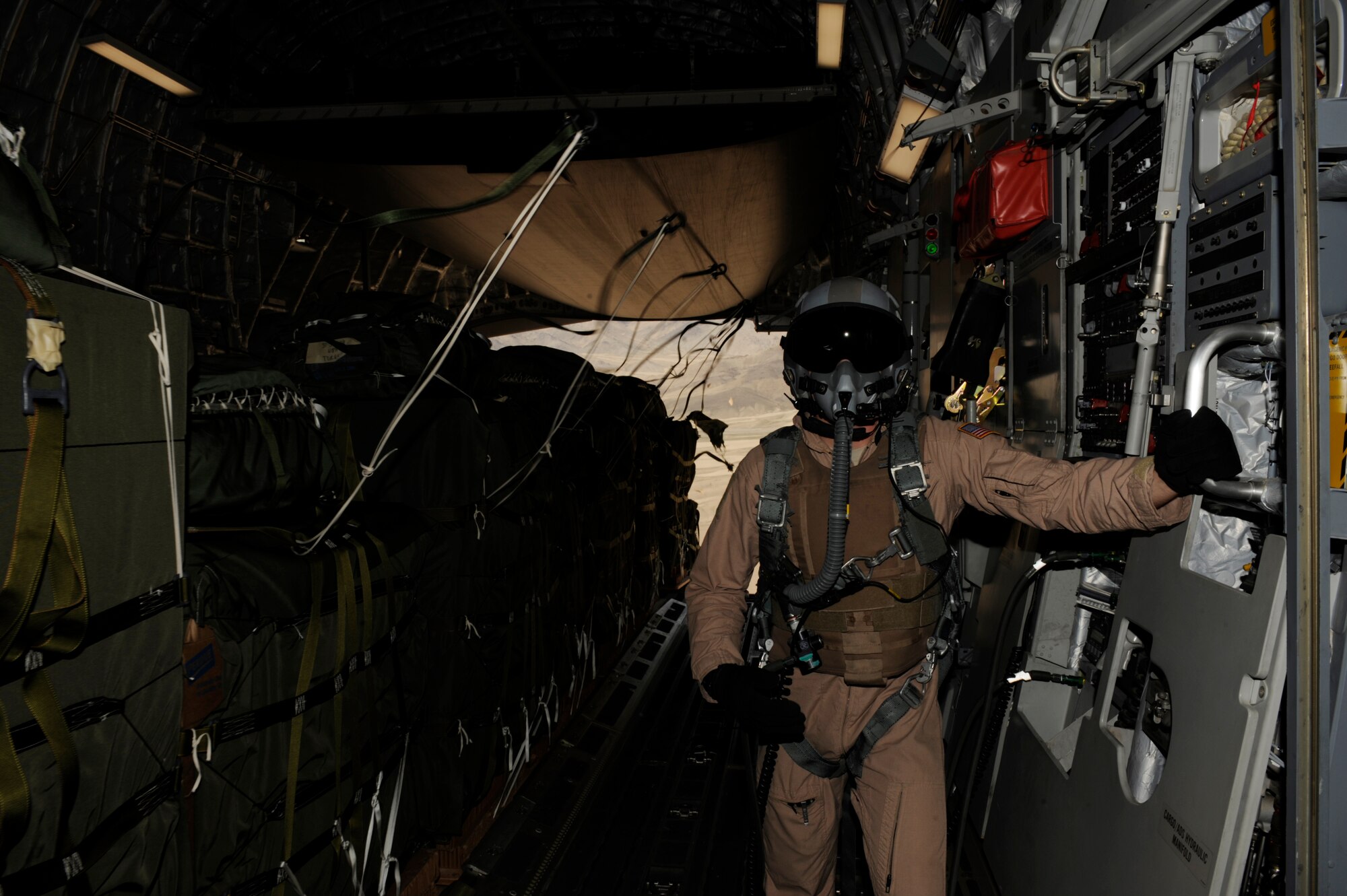 U.S. Air Force Senior Airman Rory Nowosielski, a C-17 Globemaster III loadmaster with the 816th Expeditionary Airlift Squadron, stands on the ramp as Container Delivery System (CDS) bundles exit the aircraft during a high altitude airdrop mission in Afghanistan Feb. 14, 2009, in support of Operation Enduring Freedom.(U.S. Air Force photo by Staff Sgt. James L. Harper Jr.)Released