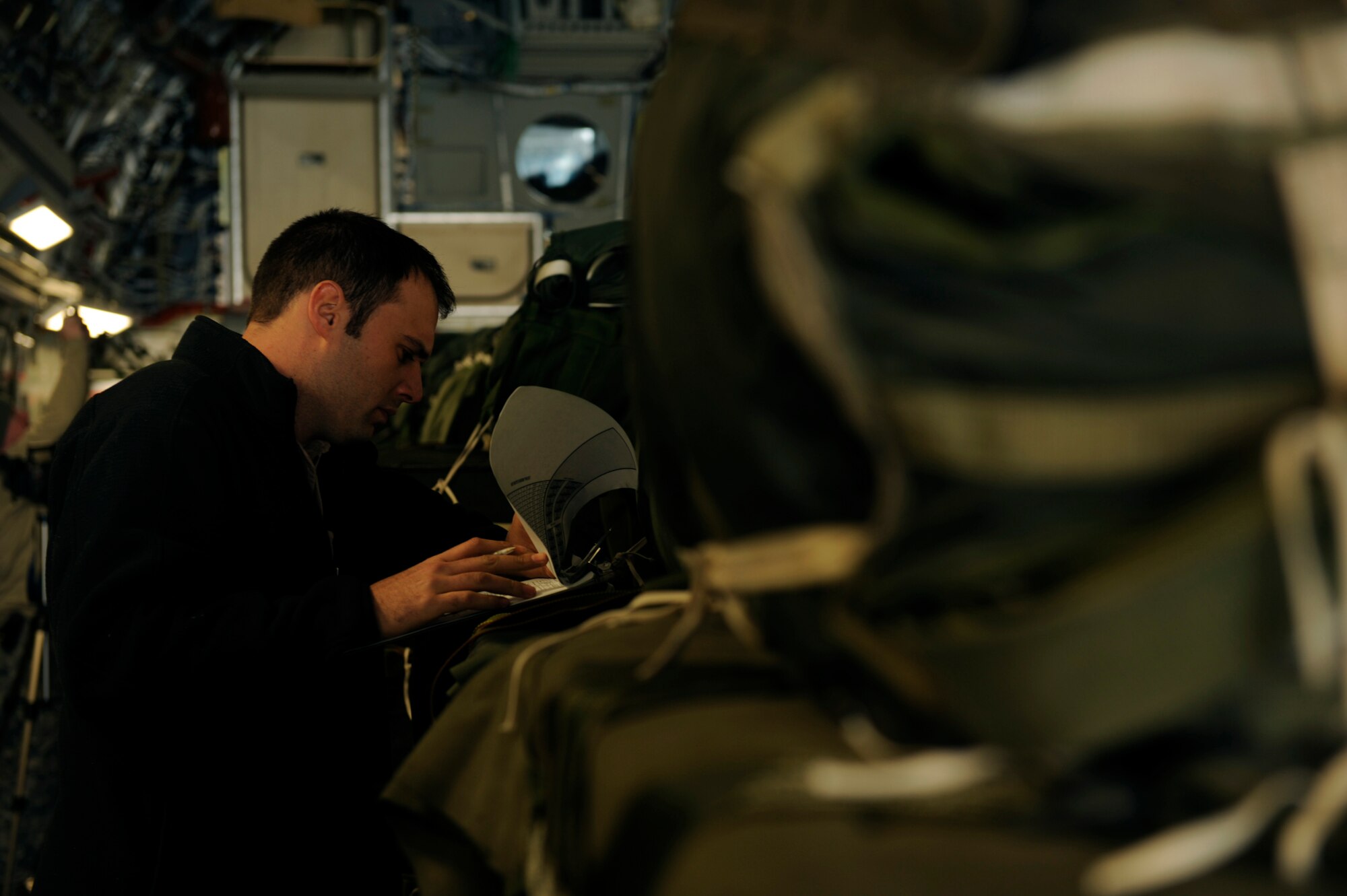 U.S. Air Force Staff Sgt. Steve Gore, a C-17 Globemaster III loadmaster, completes an airdrop evaluation prior to an airdrop mission over Afghanistan Feb. 14, 2009, in support of Operation Enduring Freedom.(U.S. Air Force photo by Staff Sgt. James L. Harper Jr.)Released