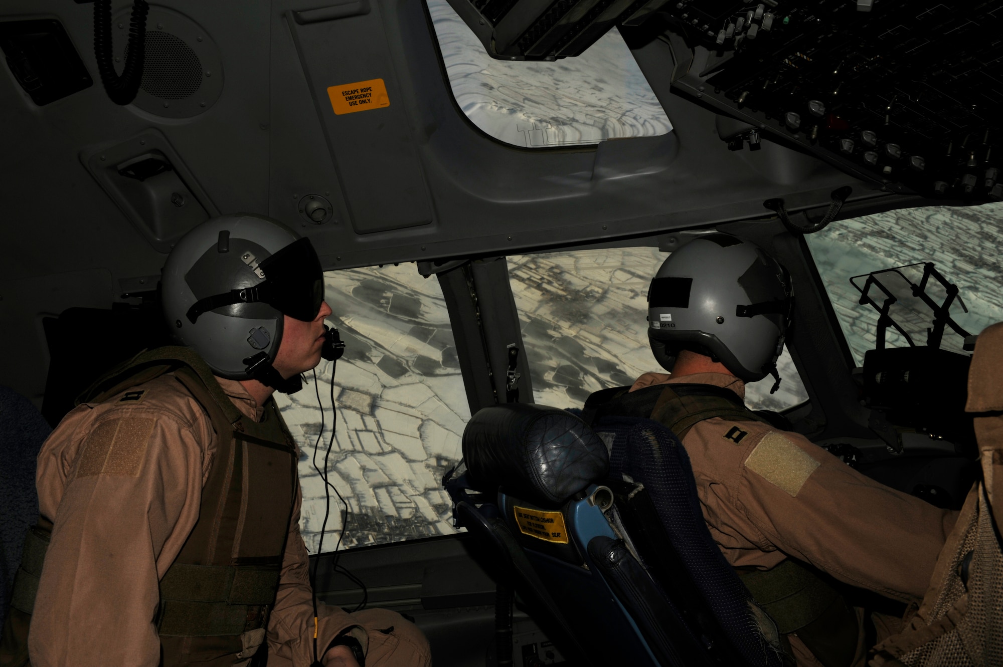 U.S. Air Force Capt. Matt Pinkerton (left), a C-17 Globemaster III pilot, scans the horizon while Capt. Joe Beal (right), also a C-17 pilot from the 816th Expeditionary Airlift Squadron, flies a mission over Afghanistan on Feb. 14, 2009, in support of Operation Enduring Freedom.(U.S. Air Force photo by Staff Sgt. James L. Harper Jr.)Released