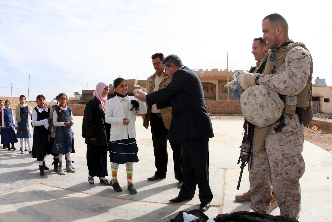 Qasim Marai Awwad, the mayor of Rutbah, Iraq, and Reserve Marines from 2nd Battalion, 25th Marine Regiment, Regimental Combat Team 8, pass out stuffed animals to girls at Shahira al-Joulan Girls Primary School in western Iraq, Feb. 16, 2009.  The stuffed animals were sent to the Marines in Iraq by Beanies for Baghdad, an official military 501(c) non-profit member of the Department of Defense’s America Supports You program.