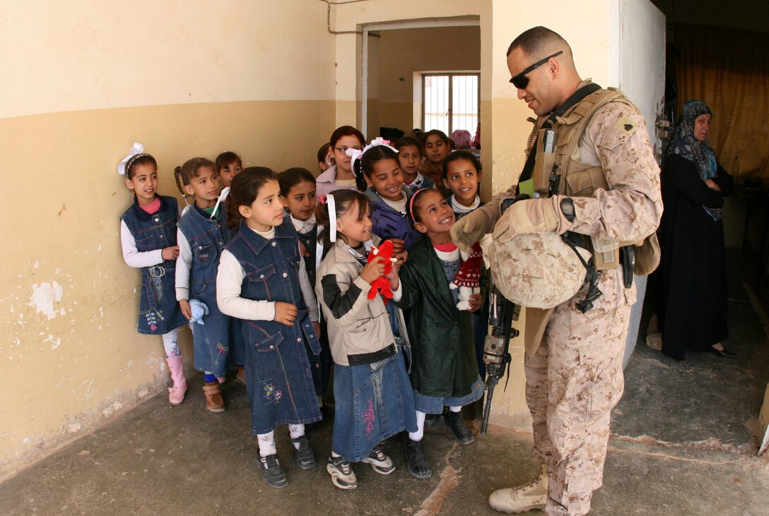 Sgt. Juan L. Pichardo of 2nd Battalion, 25th Marine Regiment, Regimental Combat Team 8, gives stuffed animals to students at Shahira al-Joulan Girls Primary School in Rutbah, Iraq during a visit by one of the battalion’s patrols, Feb. 16, 2009.  The stuffed animals were sent to the Marines in Iraq by Beanies for Baghdad, an official military 501(c) non-profit member of the Department of Defense’s America Supports You program.