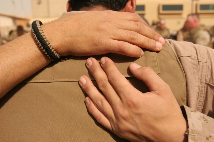 A Marine from Company A, Marine Wing Support Squadron 373, 2nd Marine Logistics Group and an Arabic interpreter embrace one other in prayer prior to departing Camp Al Taqaddum, Iraq, Feb. 16, 2009 for their mission to the village of Al Kem Al Esbani. The Marines from Company A hold the traditional prayer before each mission. (U.S. Marine Corps photograph by Cpl. Bobbie A. Curtis)