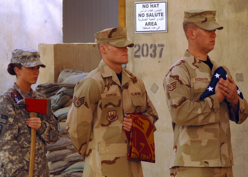 JOINT BASE BALAD, Iraq ? Firefighters carry the U.S. flag, the firefighter?s flag ,and axe as part of a remembrance ceremony honoring fallen comrade, Staff Sgt. Ray Rangel. Rangel, a fire emergency services technician, died Feb. 13, 2005, while attempting to save two Soldiers trapped in an overturned humvee in a canal. (U.S. Air Force photo/Staff Sgt. Dilia Ayala)