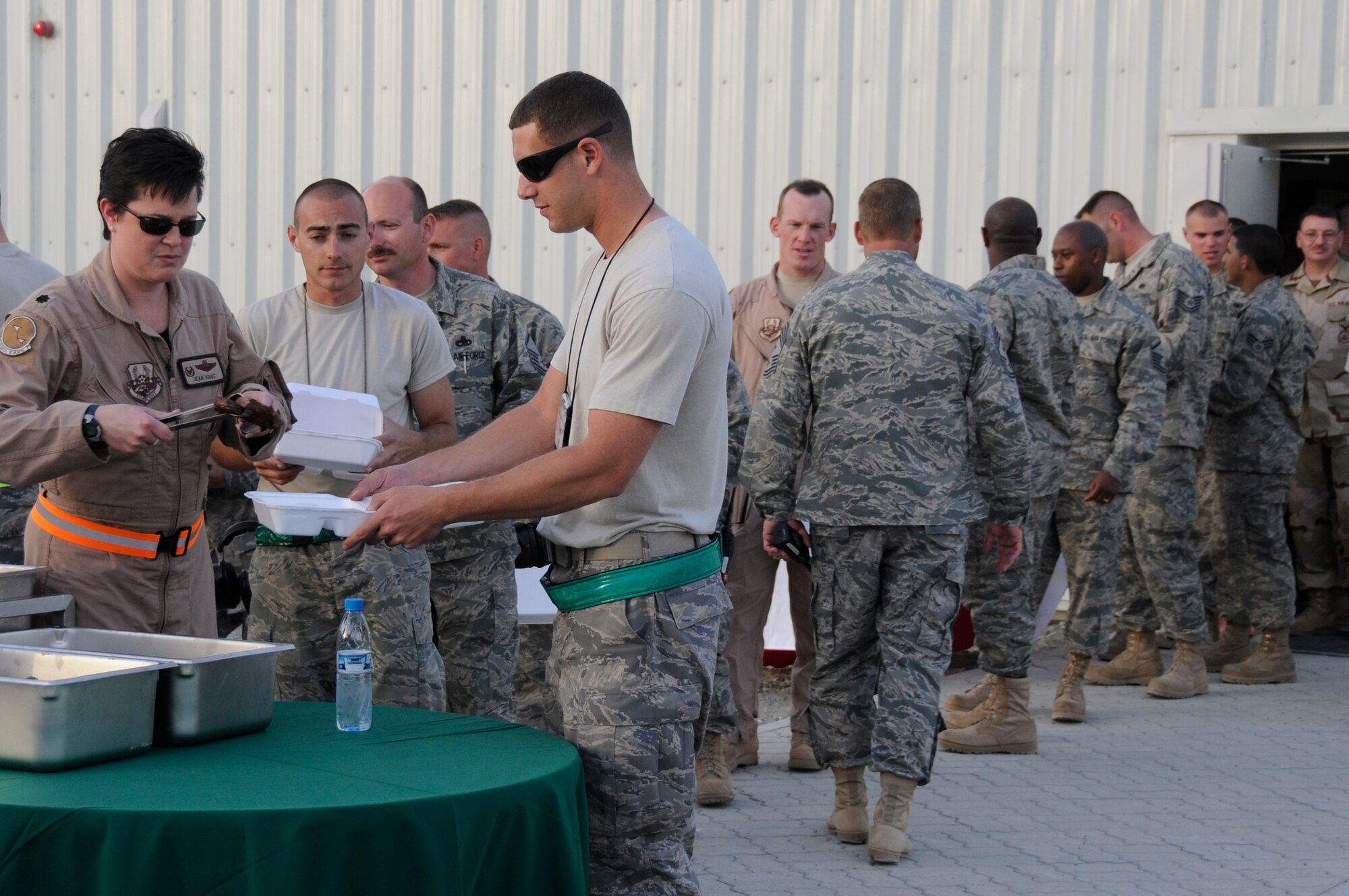 SOUTHWEST ASIA - Members of the 380th Air Expeditionary Wing line up for steaks straight from the grill at the new  flight line dining facility, Feb 15. The new facility carrying the same name as its predecessor replaced Roy's Diner, one of the last remaining Air Force tent-style dining facilities in the area of responsibility. The Sunday steak grill is a tradition carried on from the old tent style Roy's to the new Roy's diner, hardened facility. (U.S. Air Force photo by Senior Airman Brian J. Ellis) (Released)