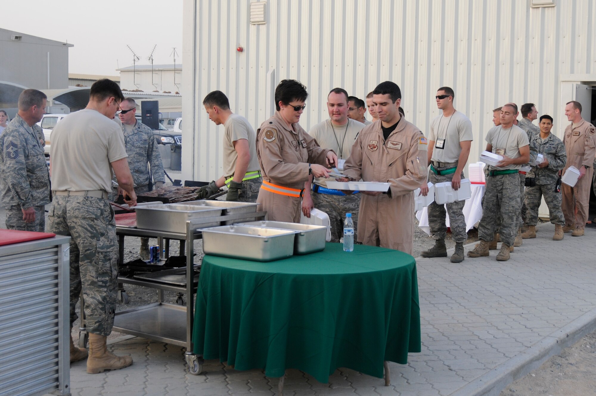 SOUTHWEST ASIA - Members of the 380th Air Expeditionary Wing line up for steaks straight from the grill at the new dining facility, Feb 15. The new facility carrying the same name as its predecessor replaced Roy's Diner, one of the last remaining Air Force tent-style dining facilities in the area of responsibility. The Sunday steak grill is a tradition carried on from the old tent style Roy's to the new Roy's diner, hardened facility. (U.S. Air Force photo by Senior Airman Brian J. Ellis) (Released)