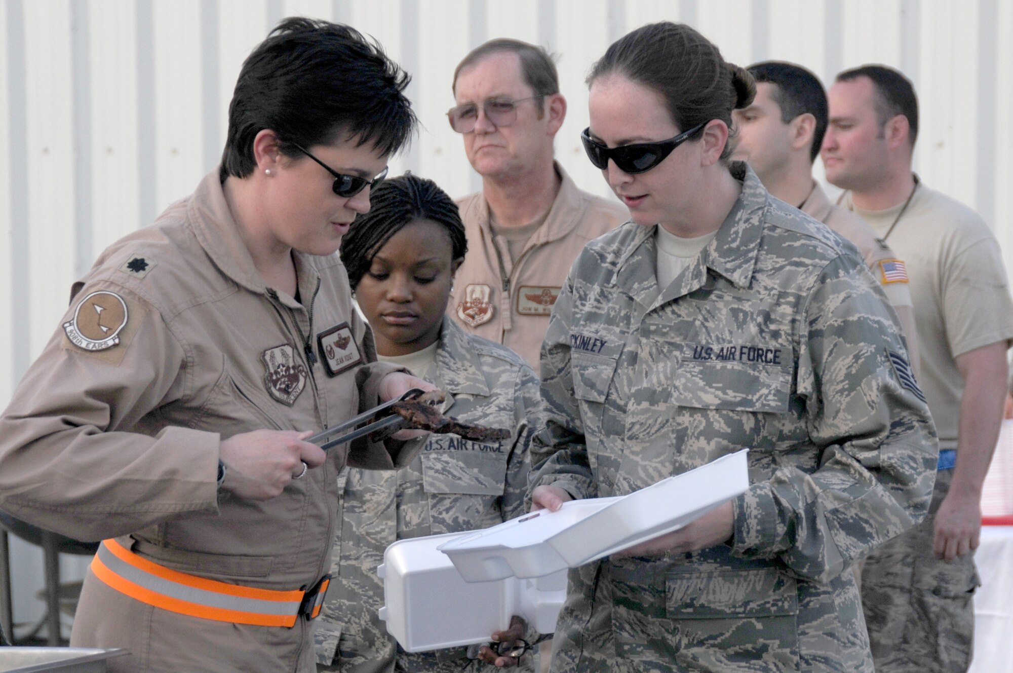 SOUTHWEST ASIA - Members of the 380th Air Expeditionary Wing line up for steaks straight from the grill at the new dining facility, Feb 15. The new facility carrying the same name as its predecessor replaced Roy's Diner, one of the last remaining Air Force tent-style dining facilities in the area of responsibility. The Sunday steak grill is a tradition carried on from the old tent style Roy's to the new Roy's diner, hardened facility. (U.S. Air Force photo by Senior Airman Brian J. Ellis) (Released)