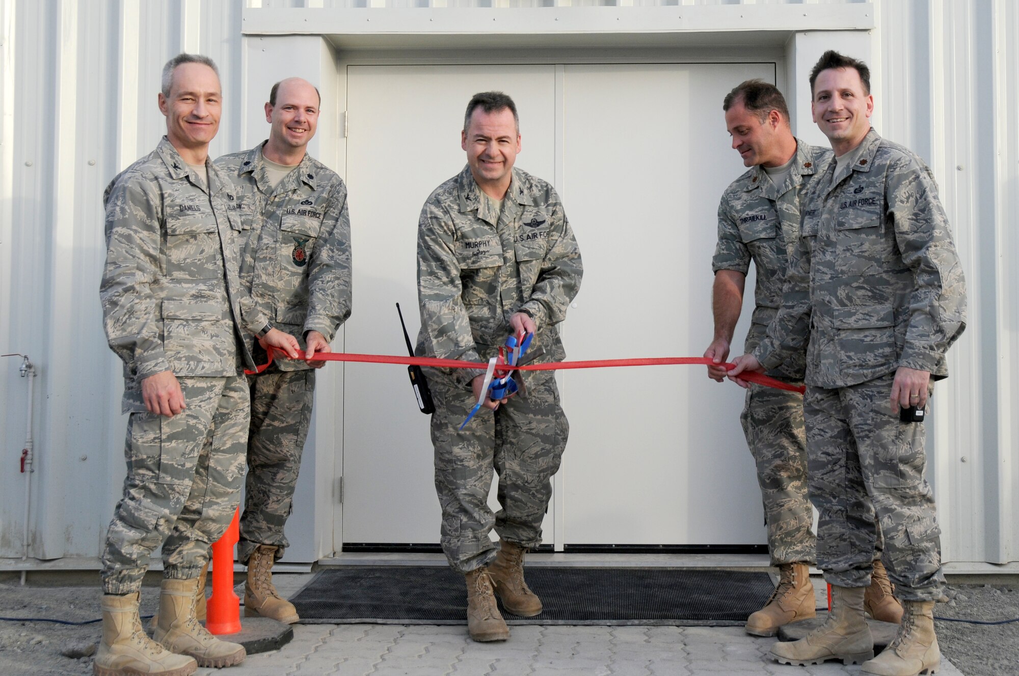 SOUTHWEST ASIA - Members of the 380th Air Expeditionary Wing leadership prepare to cut the ribbon for a new dining facility, Feb 15. The new facility carrying the same name as its predecessor, Roy's Diner, replaced one of the last remaining Air Force tent-style dining facilities in the area of responsibility. (U.S. Air Force photo by Senior Airman Brian J. Ellis) (Released)