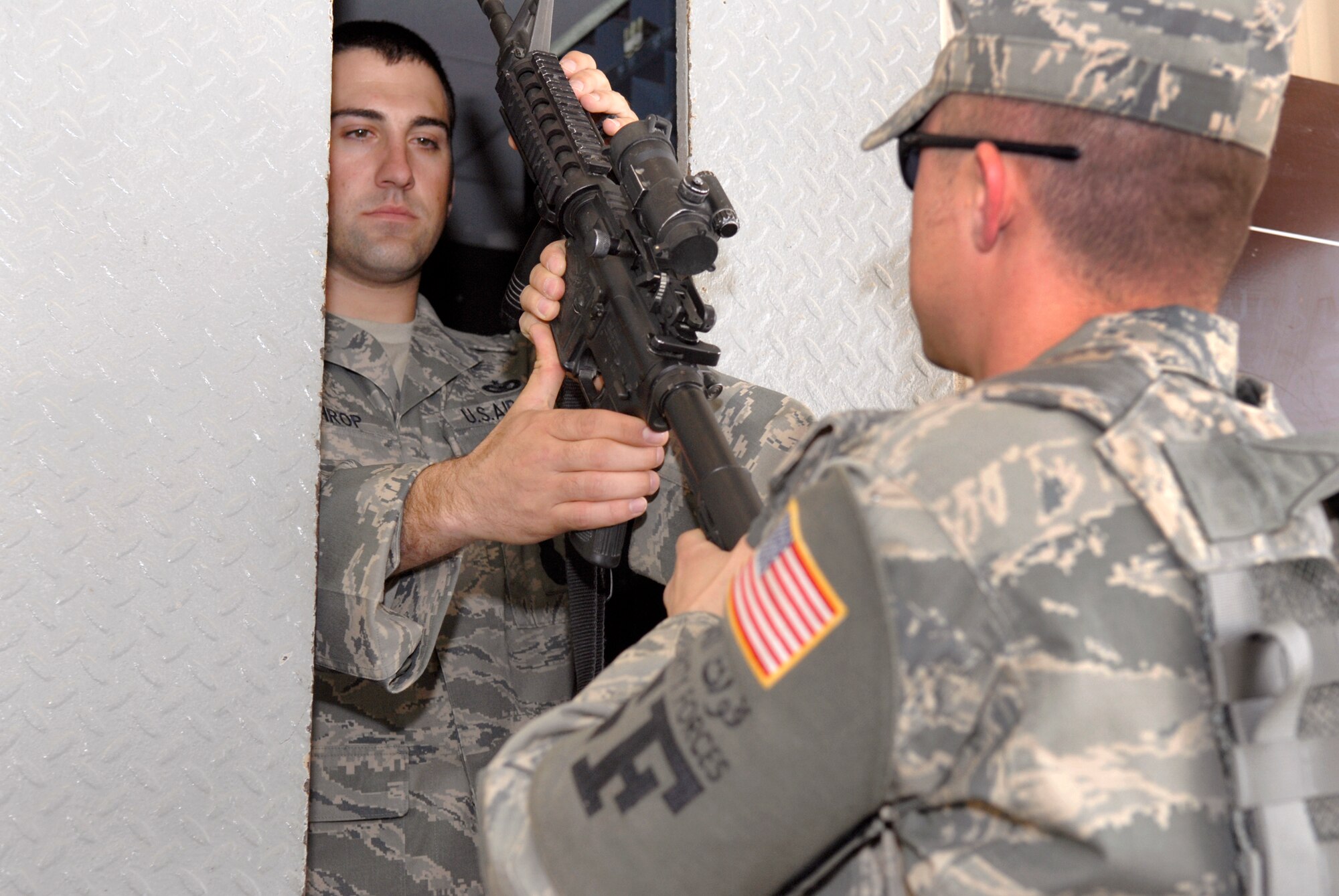 Staff Sergeant Art Lothrop, 379th Expeditionary Security Forces Squadron (ESFS) Combat Arms Training Maintenance (CATM) NCOIC, receives an M4 carbine at the armory window from Staff Sergeant Nick Wells, 379th ESFS CATM Assistant NCOIC, Feb. 15, 2009, at an undisclosed location in Southwest Asia.  Team members from CATM, issue, inspect, and maintain weapons held in the armory for the base.  Staff Sgt. Lothrop hails from Colfax, Wash. and is deployed from Tyndall Air Force Base, Fla.  Staff Sgt. Wells hails from Metropolis, Ill. and is deployed from Vogelweh Air Base, Germany.  Both are deployed in support of Operations Iraqi and Enduring Freedom and Combined Joint Task Force - Horn of Africa.  (U.S. Air Force Photo by Airman 1st Class Andrew Satran/Released)