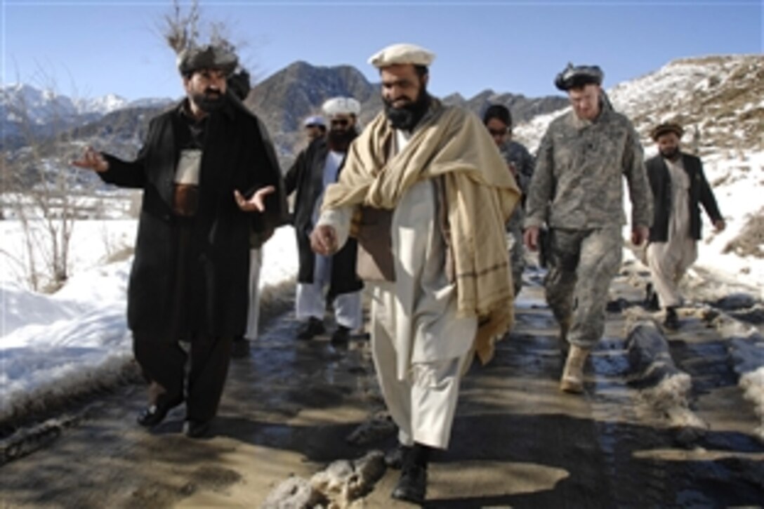 Paktia provincial Deputy Governor Abdal Rahma Mangal, left, talks with tribal leaders in the Jani Khel district during a visit by Afghan leaders and members of the Paktia Provincial Reconstruction Team to a remote village there Feb. 15, 2009. The team's commander, U.S. Air Force Lt. Col. Dan Moy, in uniform on right, walks with the group. The visit is part of the team’s efforts to connect local citizens with the provincial leadership.
