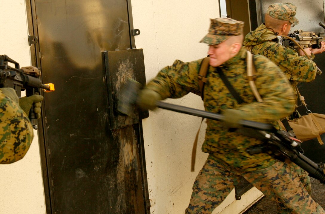 Pfc. Matthew A. Caron, 19, from Manchester, NH, uses a sledgehammer to practice breaching through a door during raid rehearsals here Feb. 16. Marines with Company F, 2nd Battalion, 4th Marine Regiment conducted mechanized raid training here Feb. 16-20. The Marines received instruction on the proper way to successfully breach doors and windows and took turns following the classes.