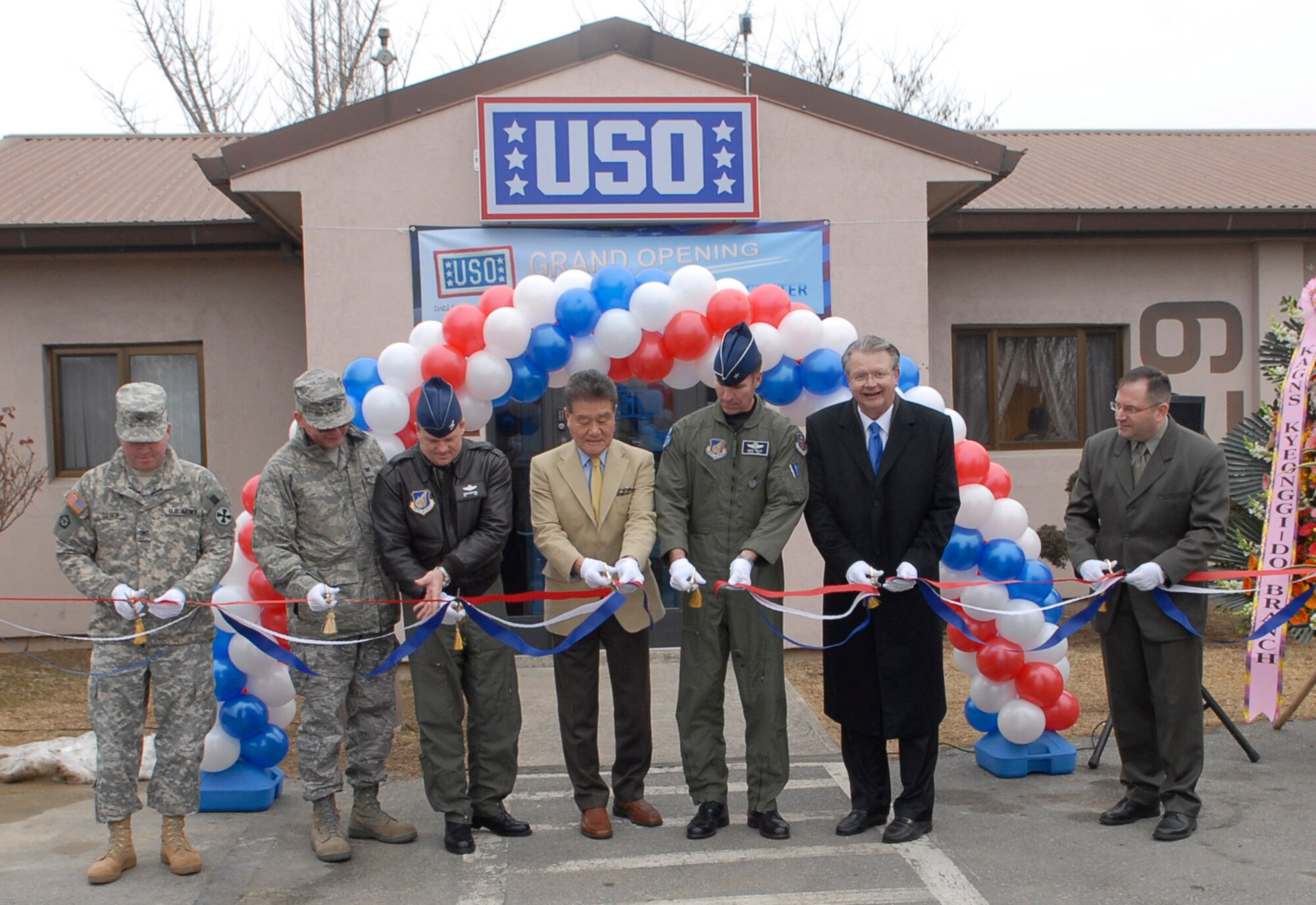 Col. E.J. Degen, (left), Col. David Penny, Col. Mark Mattison, Brig. Gen. Michael Keltz, Mr. David Proch, Mr. Mark Wood, along with a local city councilmen cut the opening ribbon at the USOs grand opening here Feb. 4. The USO is a
private, nonprofit organization that provides morale and recreational services
to members of the U.S. military worldwide. Colonel Degen is the 3rd Brigade commander, Colonel Penny is the 731st Air Mobility Squadron commander, Colonel Mattison is the 51st Fighter Wing Vice commander, General Keltz is the 7th Air Force vice commander, David Proch is the United Service Organization's director in Seoul and Mark Wood is the USO director at Osan AB. (U.S. Air Force photo/Staff Sgt. Scottie McCord)