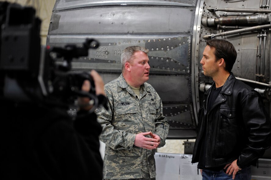 Tech. Sgt. Steven Wilson, 28th Bomb Wing Public Affairs NCO in charge, films a scene with Colby Donaldson, host of Speed Channel’s "American Thunder" , during a tour of the South Dakota Air and Space Museum, Feb. 11.  American Thunder filmed at the museum for a segment of an upcoming episode featuring attractions and cultural icons in the Black Hills area available to the public before and after the world-famous Sturgis Motorcycle Rally. (U.S. Air Force photo/Airman 1st Class Matthew Flynn)