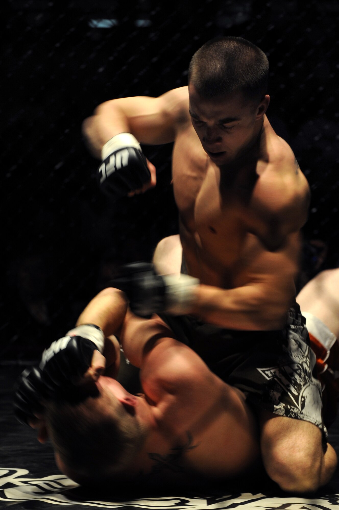 (Right to left) Airman 1st Class Elijah Van Guilder, 28th Maintenance Squadron B-1B avionics journeyman, attempts to land a punch against his opponent, Hugh Foreman, during a mixed martial arts competition at the Rushmore Plaza Civic Center in Rapid City, S.D., Feb. 13. Airman Van Guilder experienced his first career win in his debut fight by knocking out his opponent. (U.S. Air Force photo/Airman 1st Class Joshua J. Seybert)
