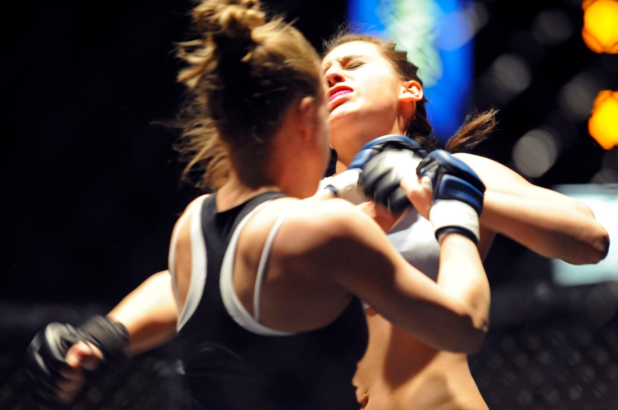 (Left to Right) Airman 1st Class Amber Motske, 28th Security Forces police officer, lands a punch on her opponent, Darian Johnson, during a match at the Rushmore Plaza Civic Center in Rapid City, S.D., Feb. 13. Five out of the 30 fighters from the mixed martial arts event are Airmen stationed at Ellsworth Air Force Base. (US Air Force photo/Airman 1st Class Corey Hook)