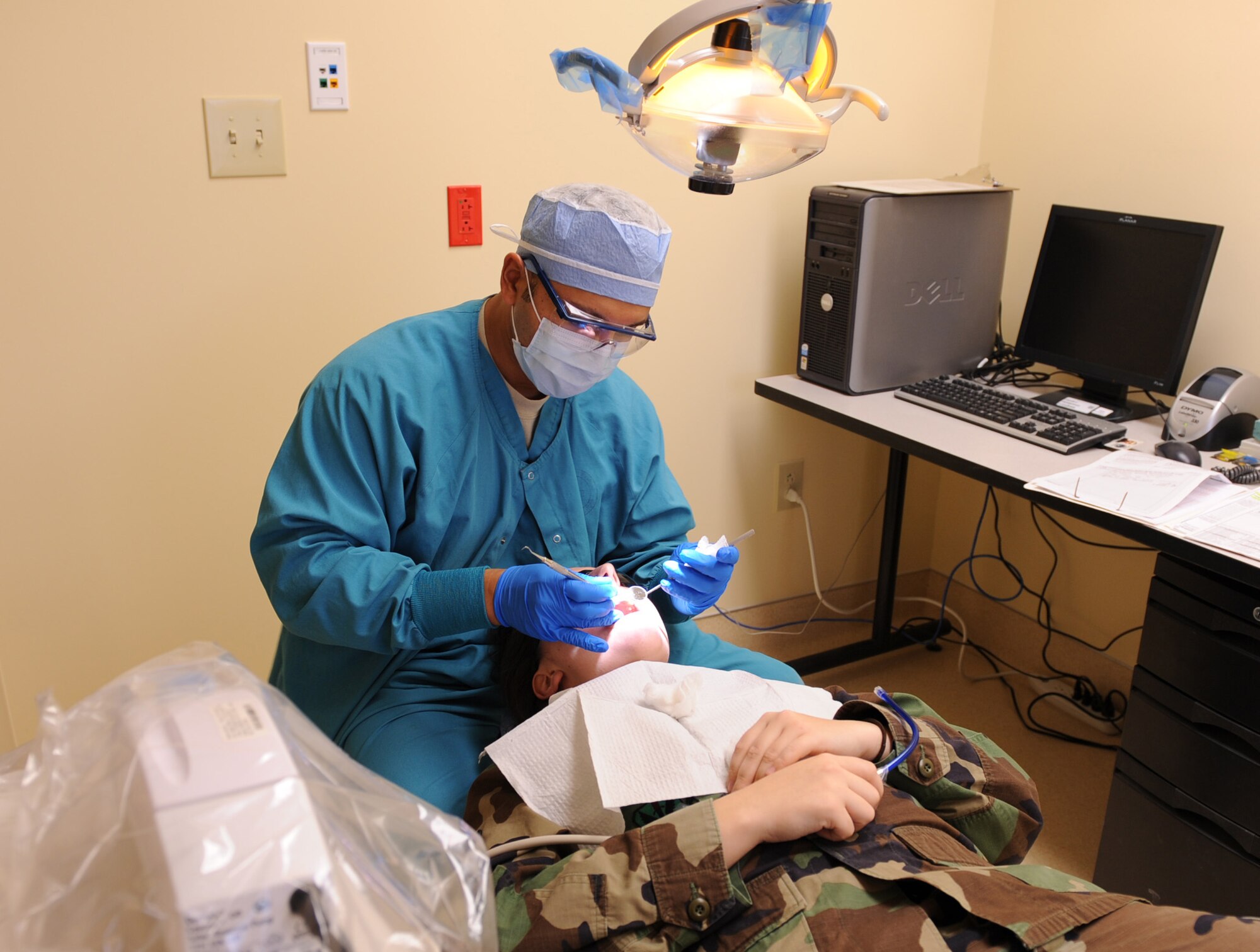 CREECH AFB, Nev. -- Technical Sergeant Rick Rodriguez, 99th Dental Squadron, dental technician, performs one of the first dental procedures on Senior Airman Allyson Lettie, 432nd Aircraft Maintenance Squadron, Predator Communications technician, at the new dental facility on Creech Air Force Base Feb. 12. The facility allows Creech Airmen access to medical care without having to commute to Nellis AFB, which has resulted in more than 40,000 saved man hours. (U.S. Air Force Photo / Airman 1st Class Stephanie Rubi)