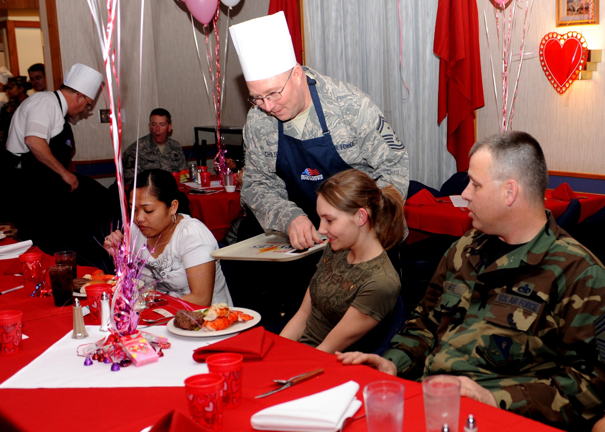 CANNON AIR FORCE BASE N.M. -- Senior Master Sgt. George Childers, 27th Special Equipment Maintenance Squadron, serves lobster at the Quarterly Birthday Meal to  Airman 1st Class Ashley Perry, 27th Special Operations Medical Support Squadron, at the Pecos Trail Dining Facility Feb 12. Wing leadership served Airmen at their tables making sure they had a comfortable dining experience. (U.S. Air Force photo by Airman 1st Class Evelyn Chavez)