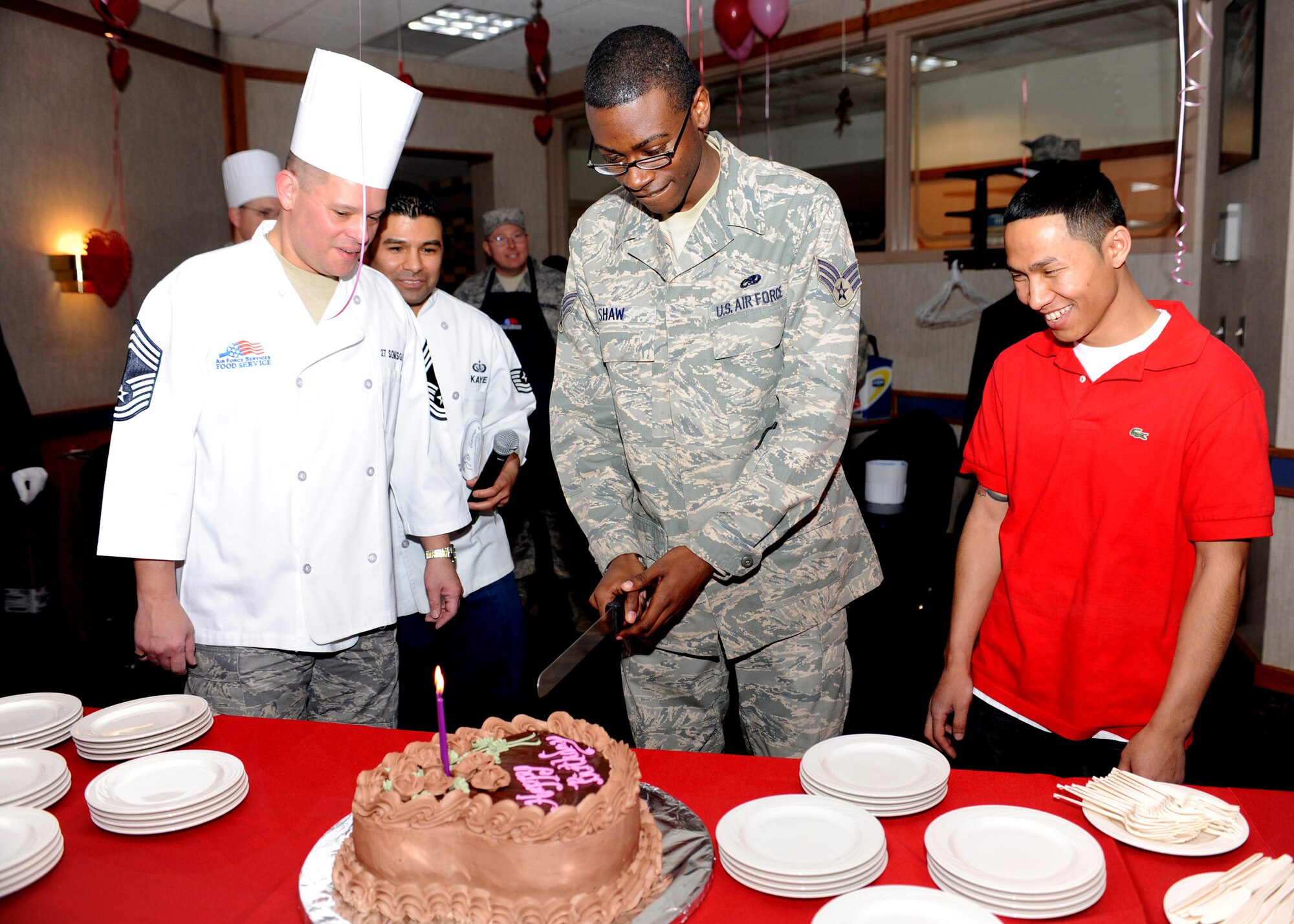 CANNON AIR FORCE BASE N.M.-- Chief Master Sgt. Hector Baez, 27th Special Operations Missions Support Group, watches Senior Airman Kenneth Shaw, 27th Special Operations Component Maintenance Squadron, and Airman 1st Class Dara Prak, 27th Special Operations Force Support Squadron, cut the birthday cake at the Quarterly Birthday Meal Feb. 12 held at the Pecos Trail Dining Facility. To continue tradition, the oldest and youngest Airmen attending the meal cut the first piece of cake. (U.S. Air Force photo by Airman 1st Class Evelyn Chavez)