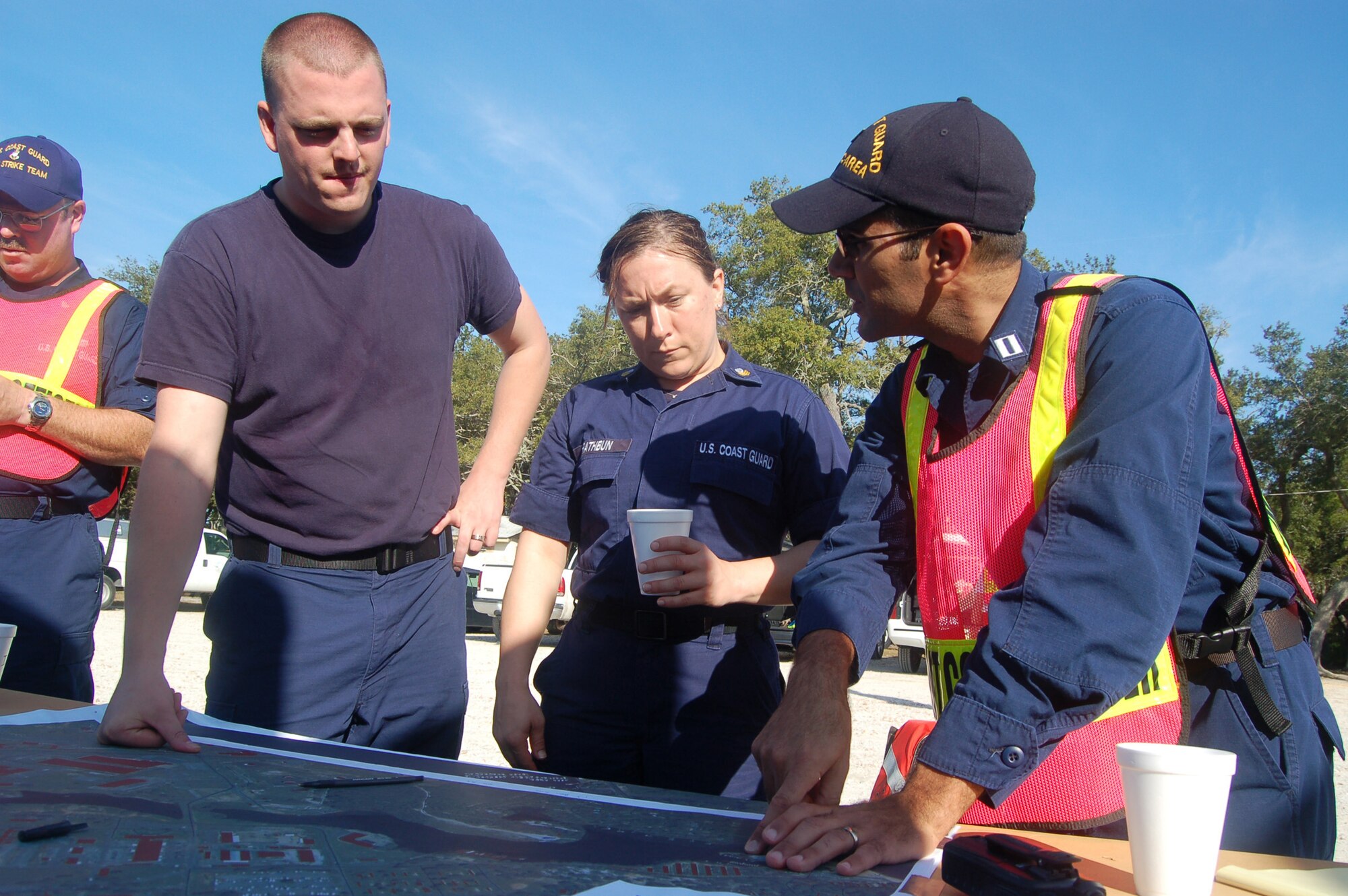 EGLIN AIR FORCE BASE, Fla. -- After removing their protective gear and going through a simulated decontamination phase, Entry Team members Petty Officer 3rd Class Carl Shepard and Petty Officer 1st Class Stephanie Rathburn share what they saw during their initial assessment of a simulated fuel spill in Weekly Bayou with Lt. Jose Caballero, incident commander, during a spill response exercise.  (U.S. Air Force photo/Jerron Barnett) 