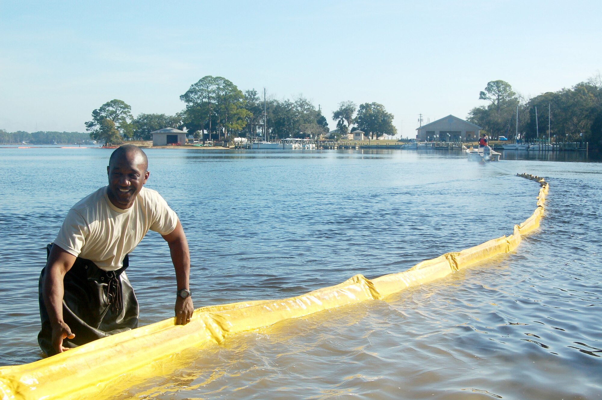 EGLIN AIR FORCE BASE, Fla. -- Capt. Trey Doby, officer in charge of the 96th Aerospace Medicine Squadron Bio-Environmental Flight's Industrial Hygiene office, feeds hundreds of feet of boom out into Weekly Bayou during a spill response exercise. (U.S. Air Force photo/Jerron Barnett) 
