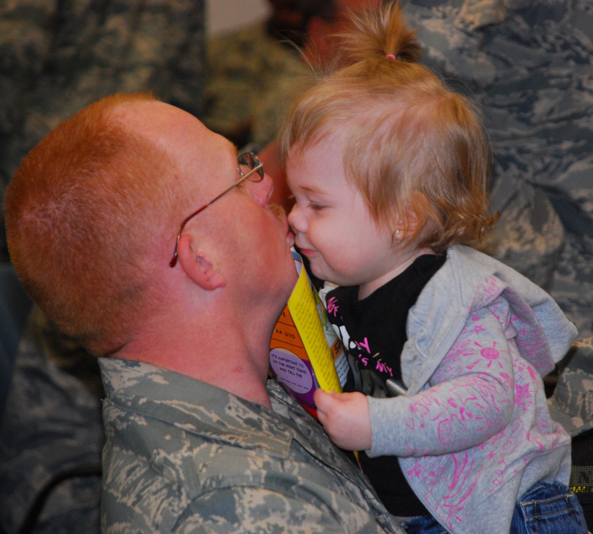 Tech. Sgt. Rodney Pollard, 301st Aircraft Maintenance Squadron, gets some sugar from his daughter before leaving today for Southwest Asia. More than 100 301st Fighter Wing troops have deployed in support of Operation Iraqi Freedom and will return in the spring. (U.S. Air Force Photo/Tech. Sgt. Julie Briden-Garcia)