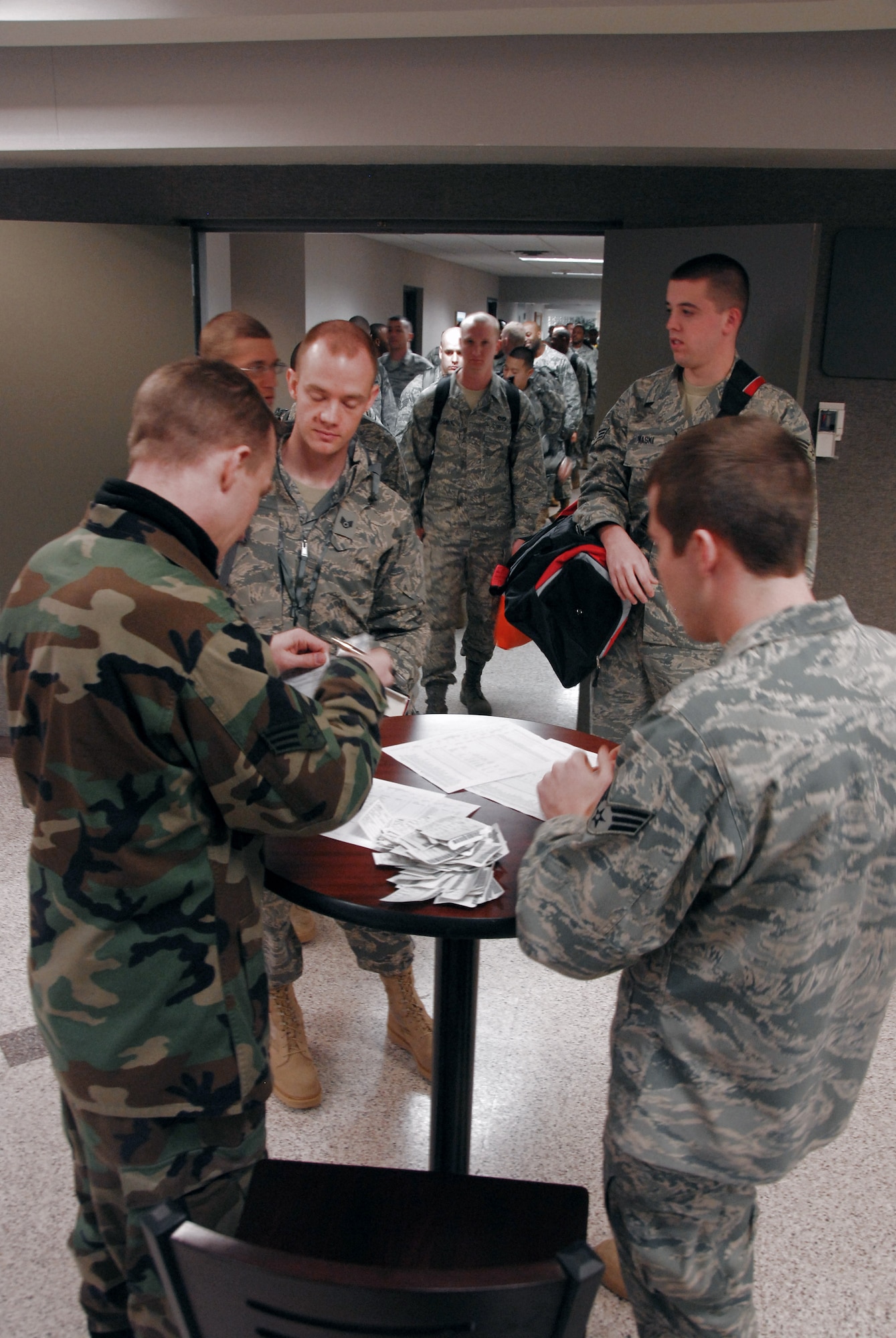 Senior Airmen Joshua Bounds, left, and Clinton Packwood, right, check in Airmen Feb. 7 in the 437th Aerial Port Squadron passenger terminal for a contracted aircraft that will take them to Southwest Asia in support of Operations Enduring and Iraqi Freedom from Charleston Air Force Base, S.C.. More than 800 Airmen from various installations throughout the Air Force have been coming to Charleston AFB since Dec. 22, 2008 to be deployed. The base is one of five aerial ports of embarkation that makes it more convenient for Airmen to deploy to the area of responsibility. Airmen Bounds and Packwood are passenger service representatives with the 437th APS. (U.S. Air Force photo/Staff Sgt. Jennifer Arredondo)