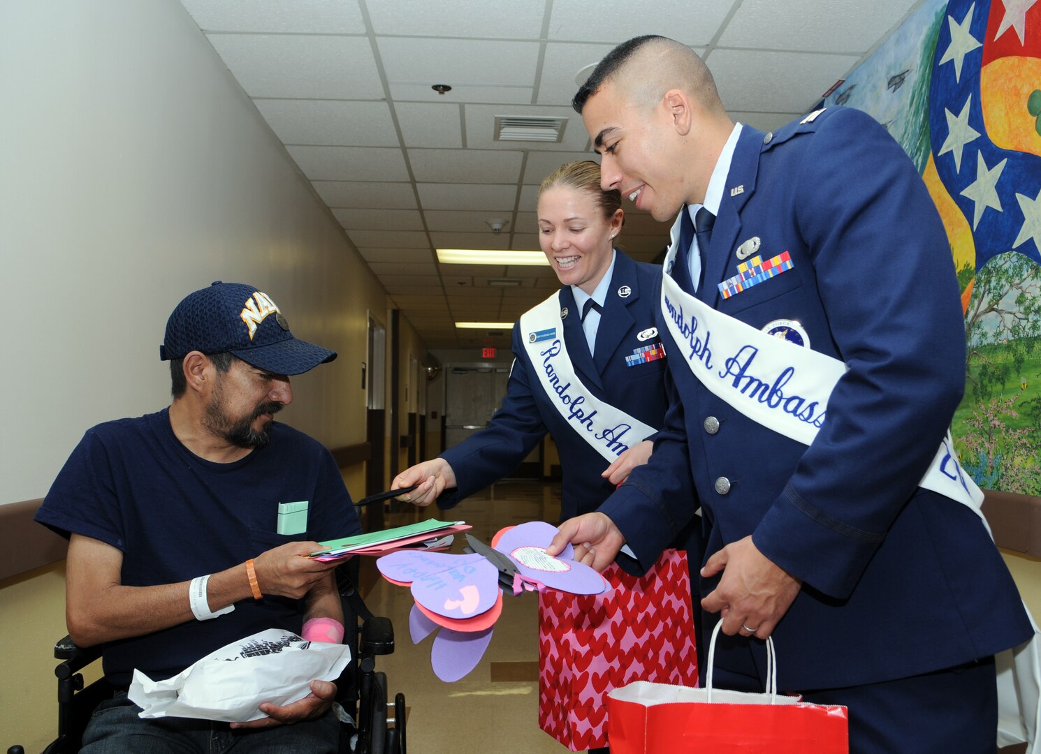 Capt. Carlos Ferrer, 341st Recruiting Squadron, and Staff Sgt. Courtney Linde, 12th Contracting Squadron, both Randolph Ambassadors, deliver hand-made Valentine's Day cards to Joe Cubillos, a veteran at Audie L. Murphy Memorial Veterans Hospital, on Feb. 13 as part of the annual National Salute to Hospitalized Veterans Program. Col. Jacqueline Van Ovost, 12th FTW commander, and Chief Master Sgt. Max Grindstaff, 12th FTW command chief master sergeant joined the ambassadors in wishing good health to fellow veterans and thanking them for their service. (U.S. Air Force photo by Don Lindsey)