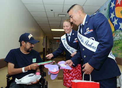 Capt. Carlos Ferrer, 341st Recruiting Squadron, and Staff Sgt. Courtney Linde, 12th Contracting Squadron, both Randolph Ambassadors, deliver hand-made Valentine's Day cards to Joe Cubillos, a veteran at Audie L. Murphy Memorial Veterans Hospital, on Feb. 13 as part of the annual National Salute to Hospitalized Veterans Program. Col. Jacqueline Van Ovost, 12th FTW commander, and Chief Master Sgt. Max Grindstaff, 12th FTW command chief master sergeant joined the ambassadors in wishing good health to fellow veterans and thanking them for their service. (U.S. Air Force photo by Don Lindsey)
