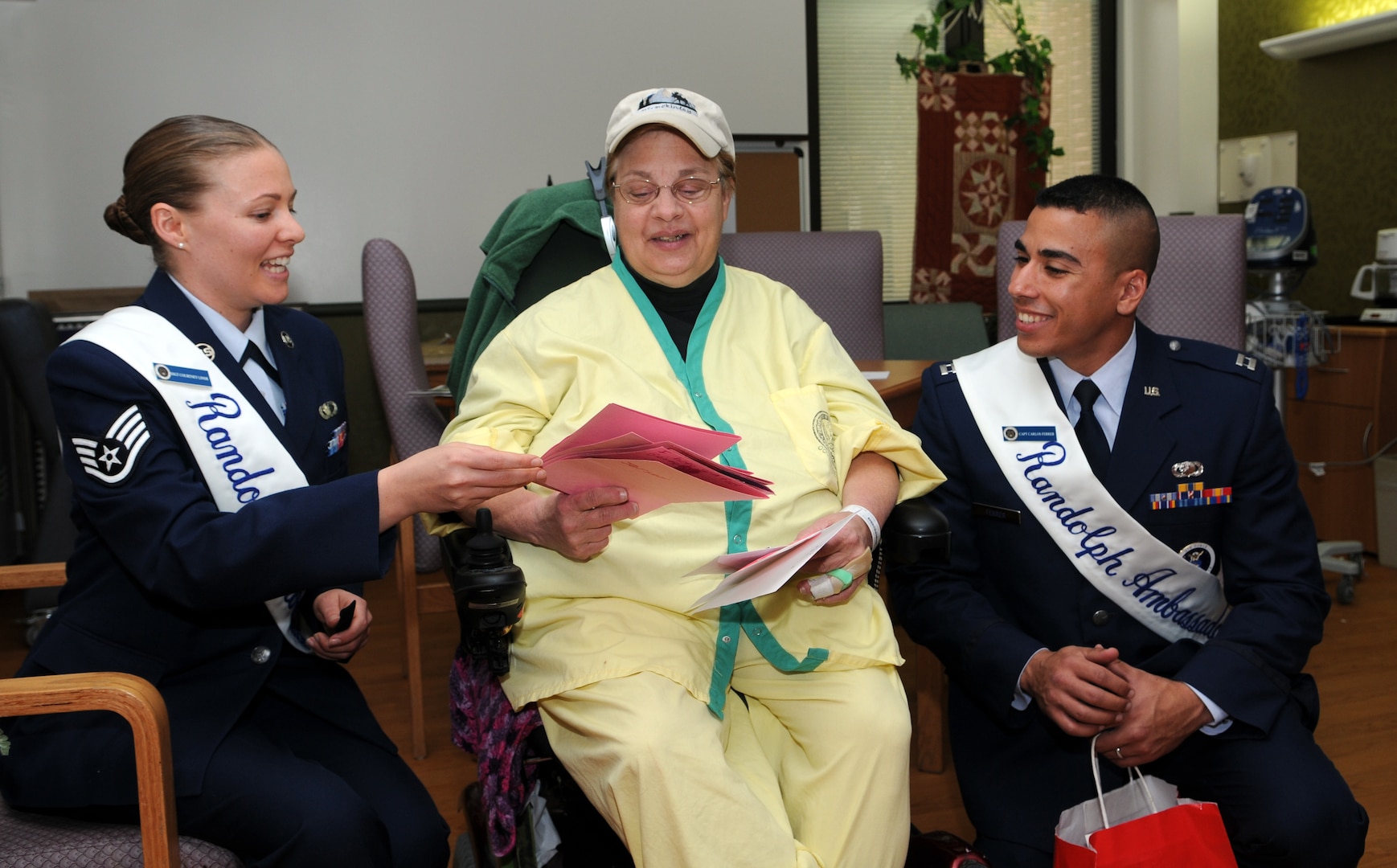 Capt. Carlos Ferrer, 341st Recruiting Squadron, and Staff Sgt. Courtney Linde, 12th Contracting Squadron, both Randolph Ambassadors, deliver hand-made Valentine's Day cards to Pat Webber, a veteran's wife, at Audie L. Murphy Memorial Veterans Hospital on Feb. 13 as part of the annual National Salute to Hospitalized Veterans Program. Col. Jacqueline Van Ovost, 12th FTW commander, and Chief Master Sgt. Max Grindstaff, 12th FTW command chief master sergeant joined the ambassadors in wishing good health to fellow veterans and thanking them for their service. (U.S. Air Force photo by Don Lindsey)