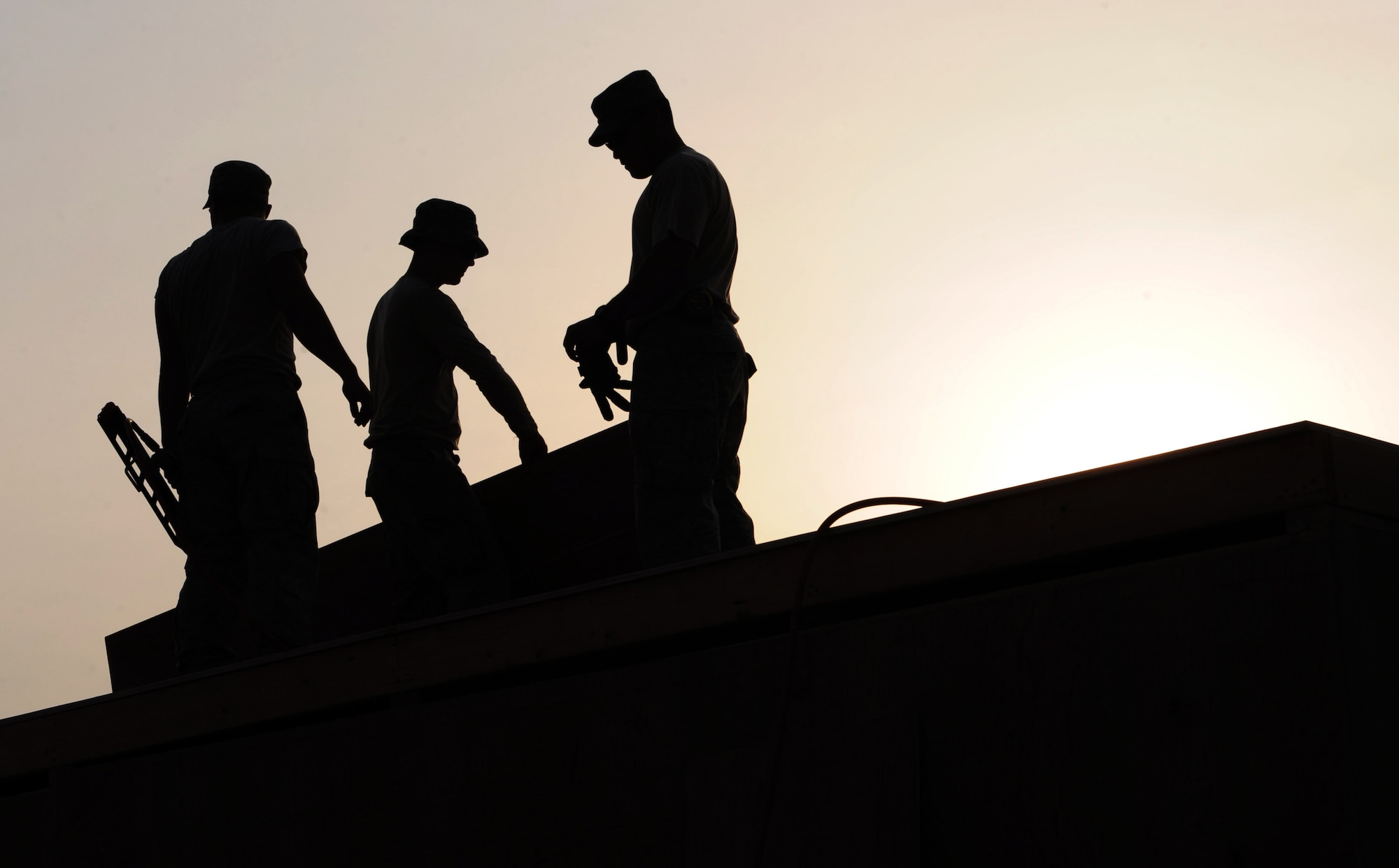 Joint expeditionary tasking Airmen from the 732nd Expeditionary Civil Engineer Squadron work until sunset to finish building a shower unit for Soldiers deployed to Forward Operating Base Hunter, Iraq, Feb. 8. The JET Airmen worked to complete three shower units for Soldiers deployed here as well as to provide power and heating to 64 tents. (U.S. Air Force photo/Senior Airman Elizabeth Rissmiller)