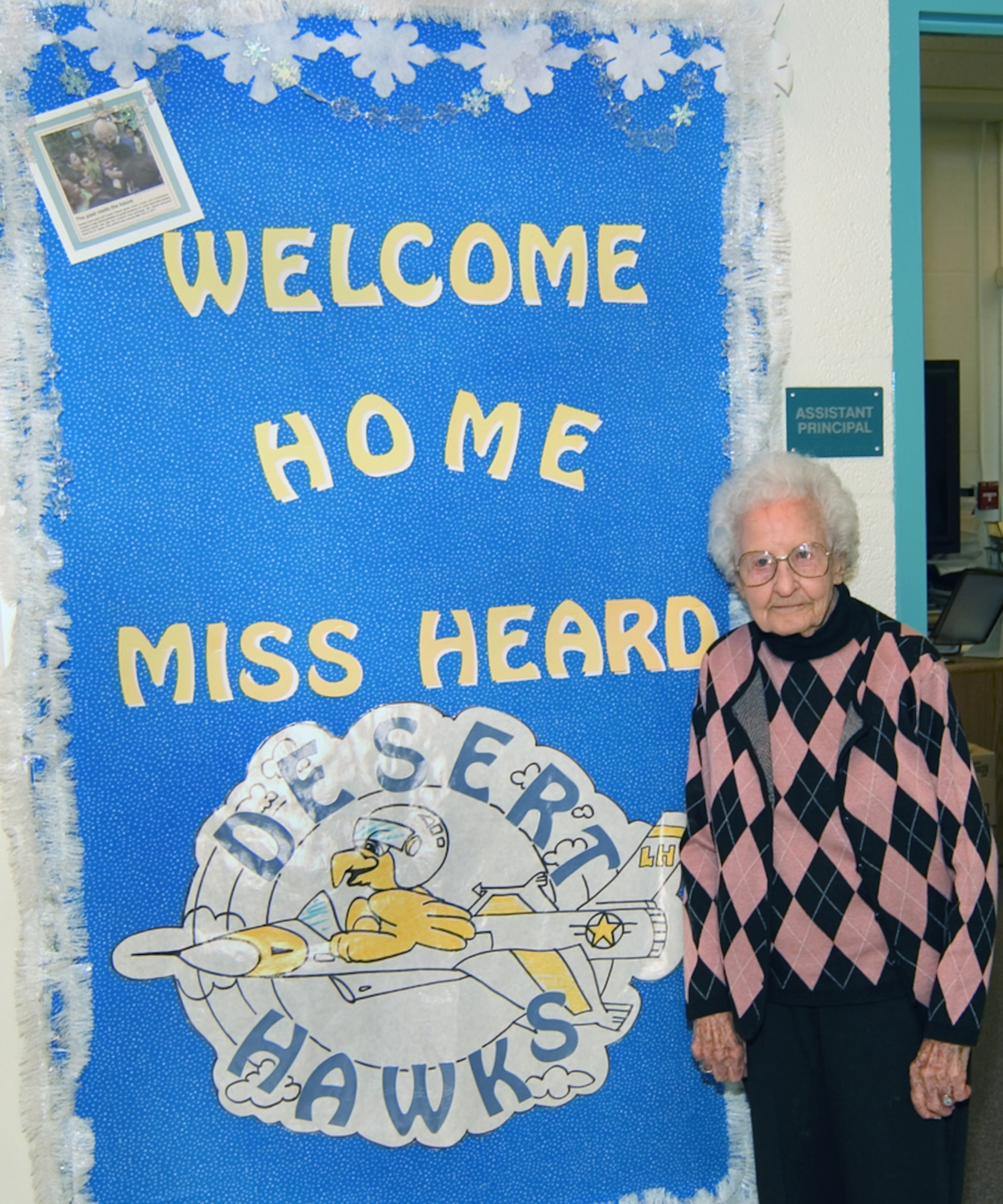 Ms. Lomie Heard stands in front of a welcome sign at Lomie Heard Elementary School. Ms. Heard impacted the lives of countless military children during her 21 years as principal of Nellis Air Force Base School, which was later, renamed Lomie Gray Heard Elementary School in her honor. (U.S. Air Force photo provided by Lomie Heard Elementary School)