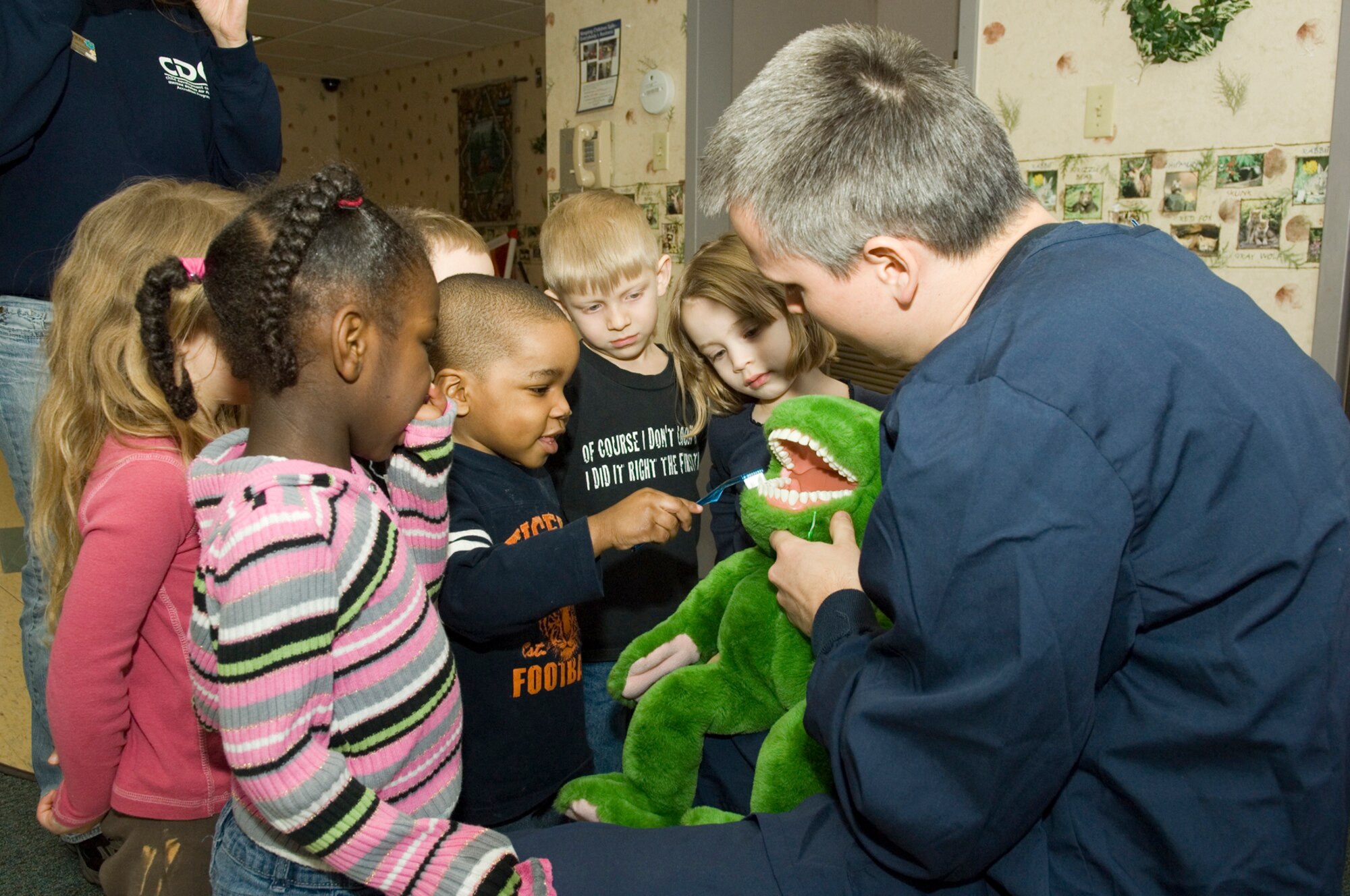 HANSCOM AIR FORCE BASE, Mass. – Capt. (Dr.) Adam Egge of the 66th Medical Group, Dental Clinic, teaches children from Room 5 at the Child Development Center how to properly brush their teeth. Members of the Dental Clinic have been promoting the benefits of good oral hygiene to children across the base as part of their Children’s Dental Health Month awareness campaign. (U.S. Air Force photo by Rick Berry) 
