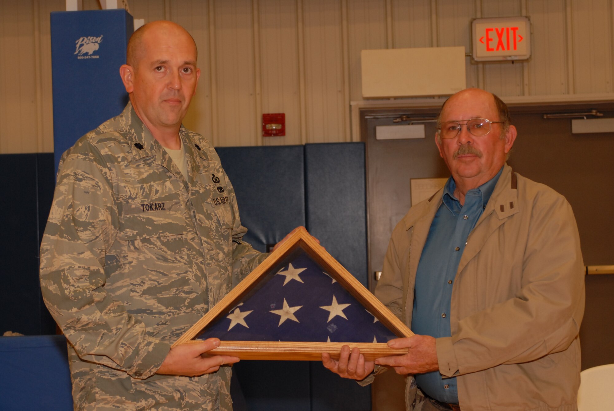 Lt Col Mike Tokarz, 134 ACS Commander, presents the recovered flag to Mr. Gene West, Chariman of the County Commissioners and fifth generation Greensburg resident.  