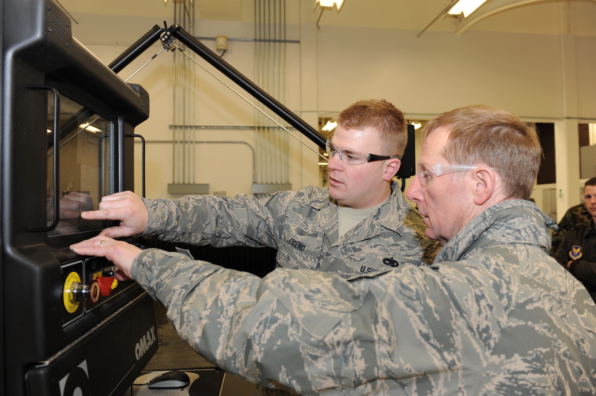 WHITEMAN AIR FORCE BASE, Mo. – Lt. Gen. Ronald Sams, Inspector General of the Air Force, observes operation of a waterjet used to fabricate aircraft parts demonstrated by Staff Sgt. Andrew Friend, 509th Aircraft Maintenance Squadron metals technician, Feb. 13. General Sams visited Whiteman as the guest speaker for the Maintenance Professional of the Year ceremony. (U.S. Air Force photo/Staff Sgt. Charles Larkin)           