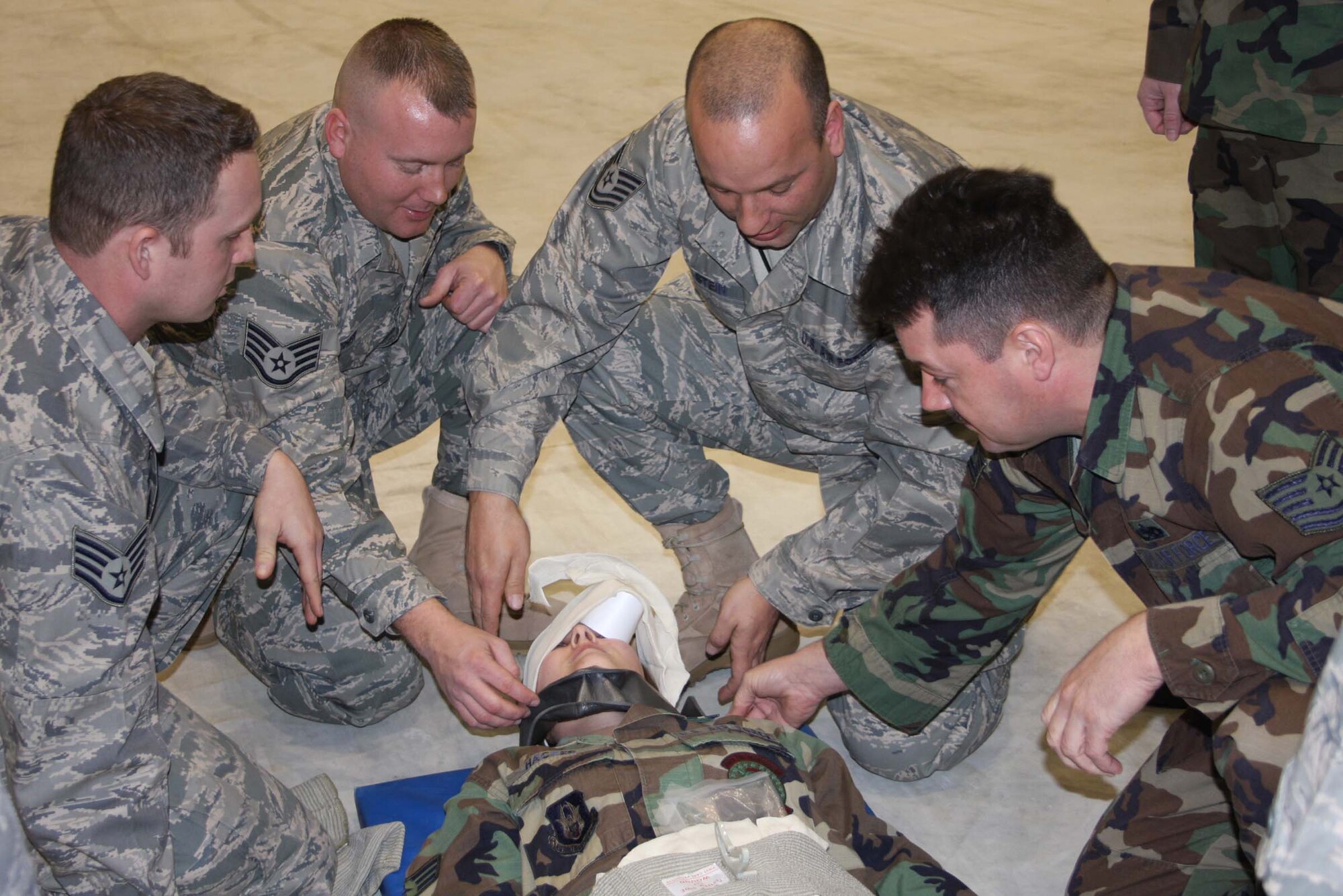 WRIGHT-PATTERSON AFB, Ohio – Members from the 445th Maintenance Squadron are working on Senior Airman Hacker's simulated injuries during the Self Aid Buddy Care portion of the 7 and 8 February weekend mega-training event.  From left to right:  Staff Sgt. Billingsley, Staff Sgt. Fisher, Tech Sgt. Stein, and Tech Sgt. Todd.  (Air Force photo/Capt. Caoline Wellman)