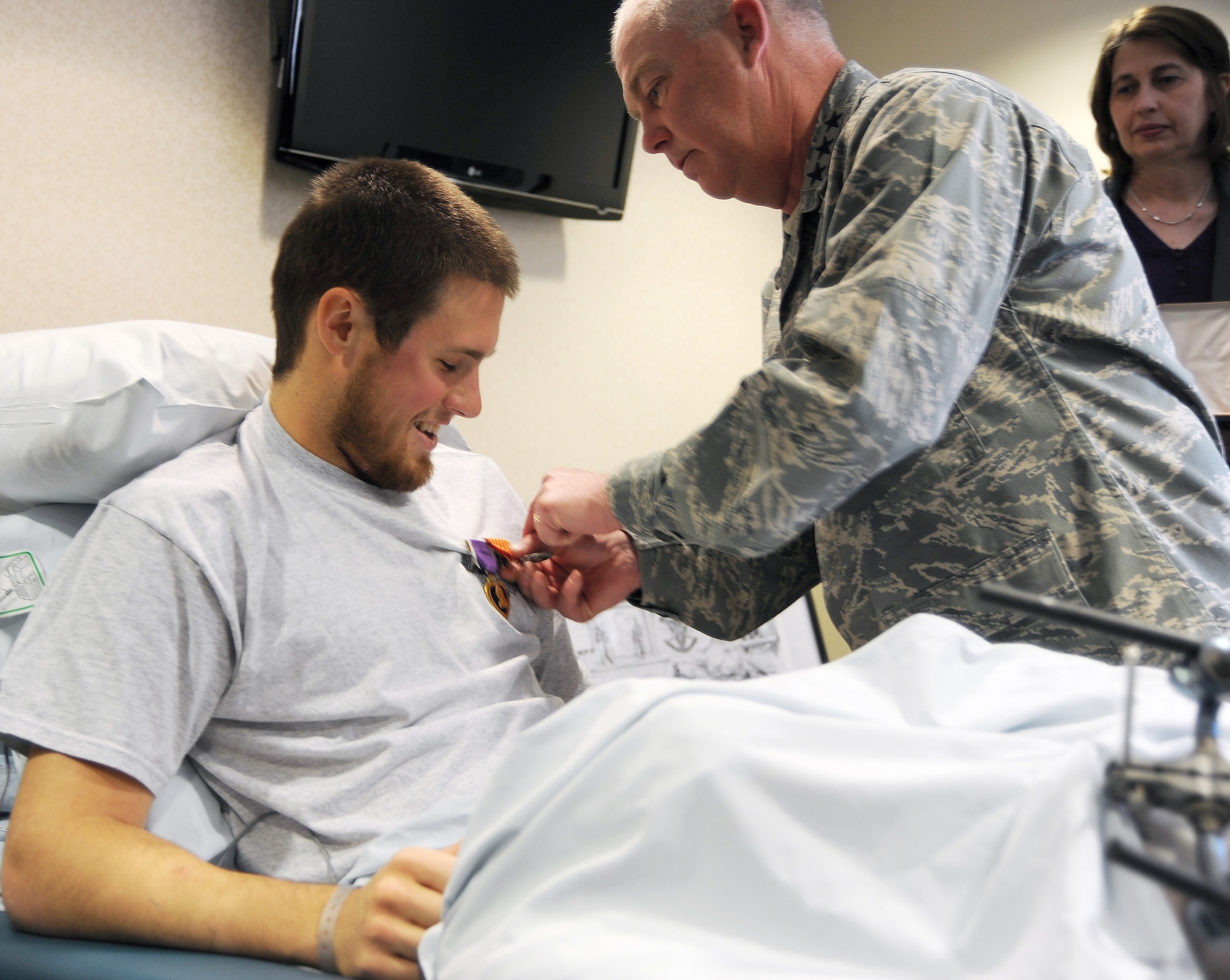 Lt. Gen. Donny Wurster, commander of Air Force Special Operations Command, pins the Air Force Combat Action Medal on Senior Airman Alex Eudy's shirt during an informal ceremony at the hospital here Feb. 3. Airman Eudy also received the Purple Heart for injuries he received during his deployment in Afghanistan. An improvised explosive device destroyed the vehicle he and five other U.S. military members were traveling in Jan. 23. All six survived the attack. Airman Eudy is a special operations weatherman in the 10th Combat Weather Squadron at Hurlburt Field, Fla.  (U.S. Air Force photo/Chief Master Sgt. Ty Foster) 
